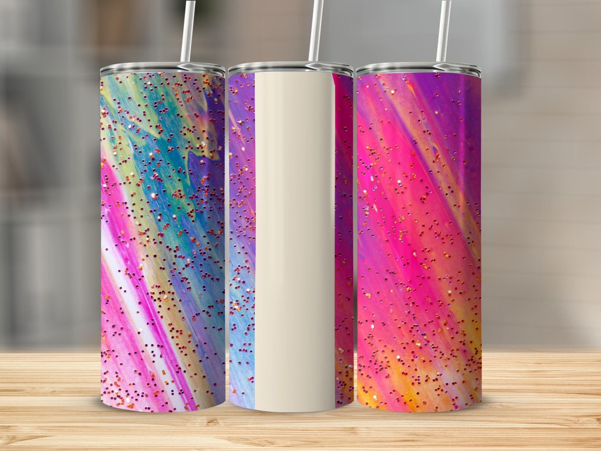 Three tumblers with vibrant, colorful splatter designs and glitter accents.