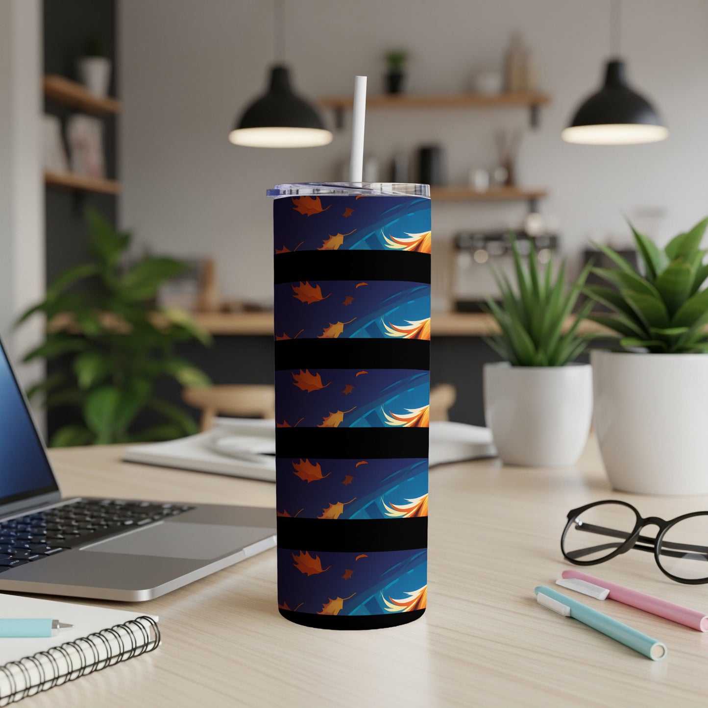 Tall tumbler with falling autumn leaves design and white straw.