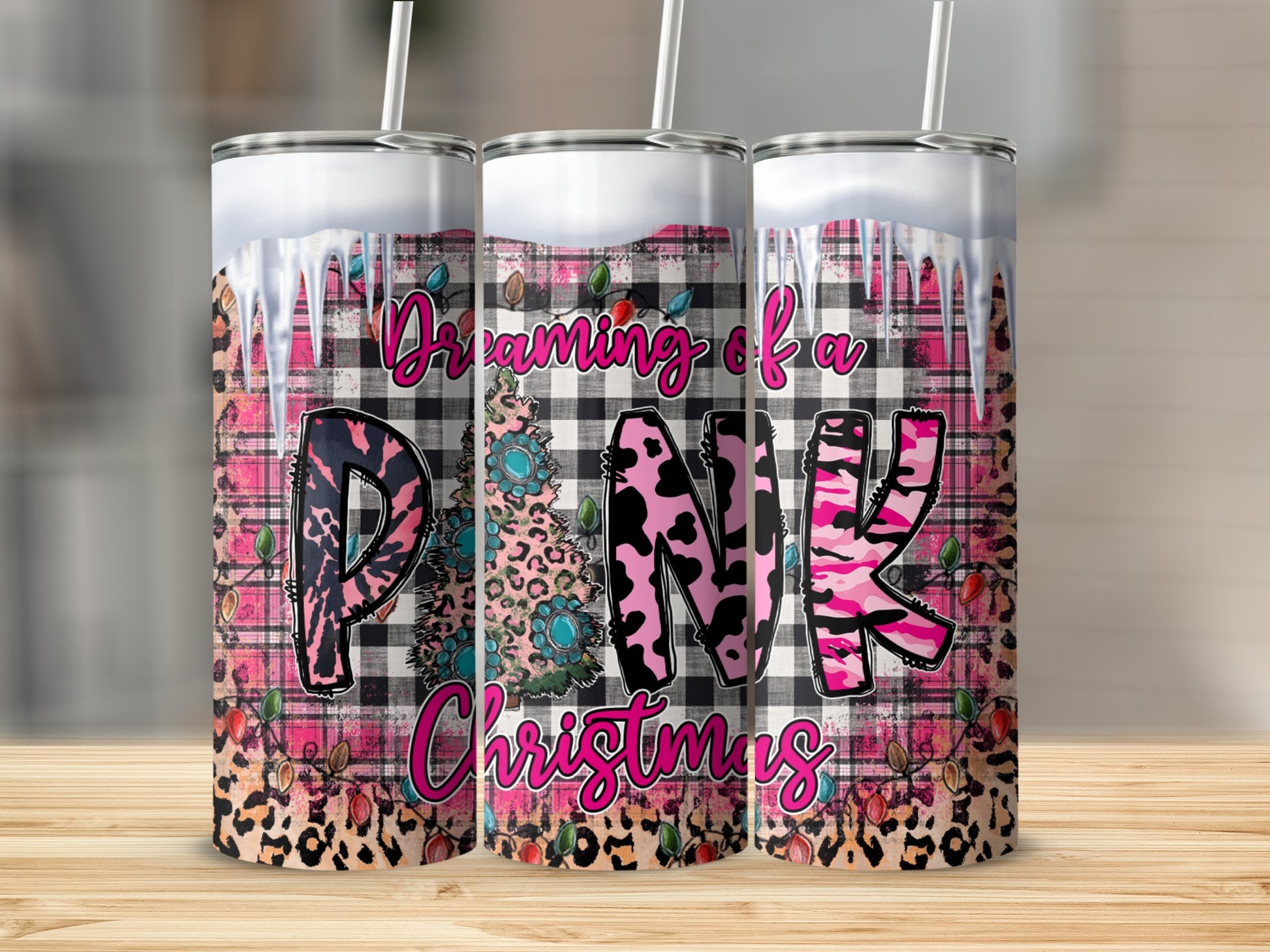 Three tumblers with pink, black, and white plaid, leopard print, and Christmas tree designs.