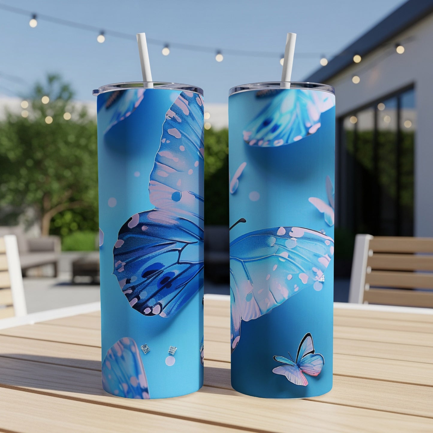 Two tall blue tumblers with large butterfly designs, sitting on a table.