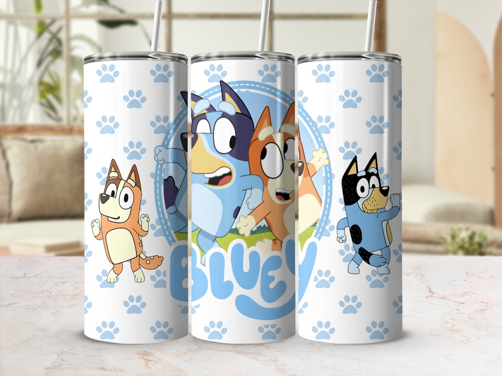 Bluey, Bingo, and Bandit characters on a white tumbler with paw prints.