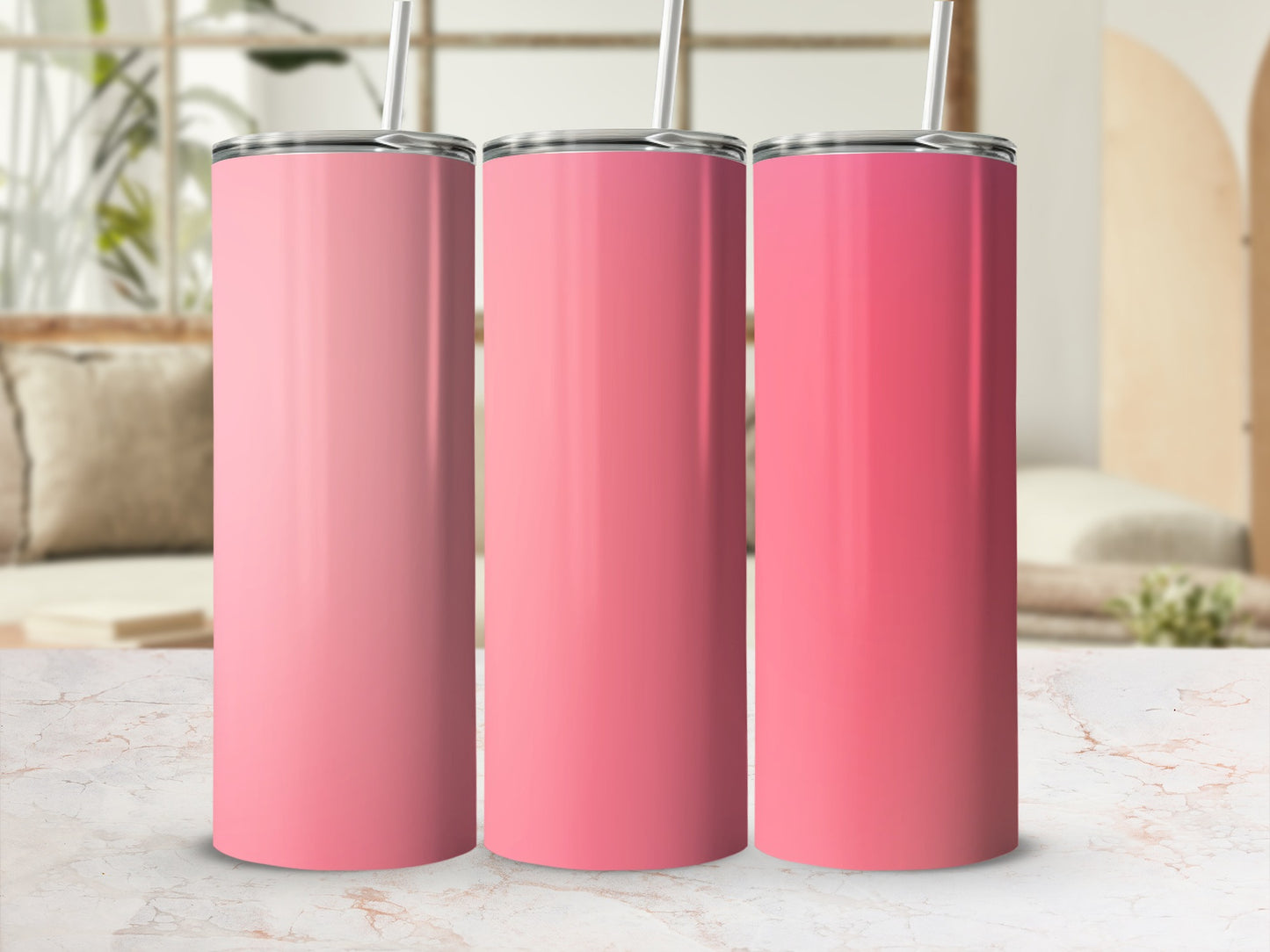 Three pink tumblers with straws on a marble surface.