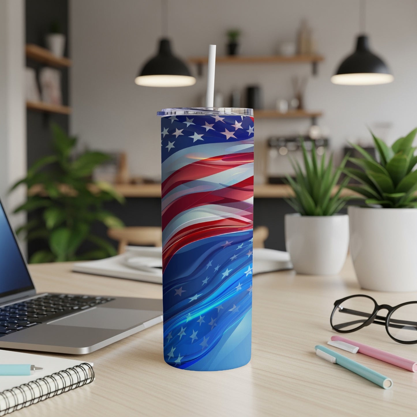 Blue tumbler with American flag design and white straw on a desk.
