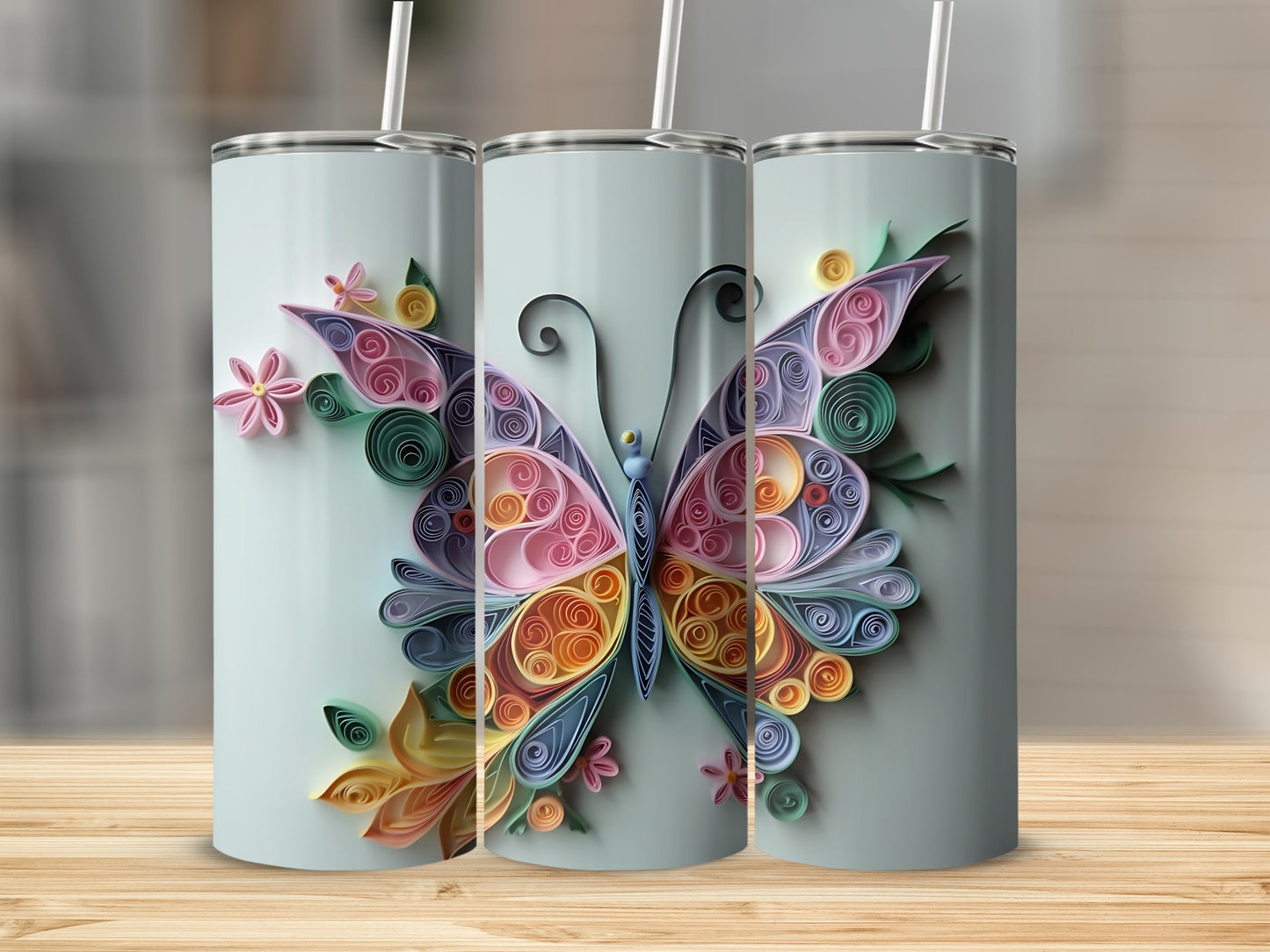 Three tumblers featuring quilled paper butterfly and floral designs in pastel colors.