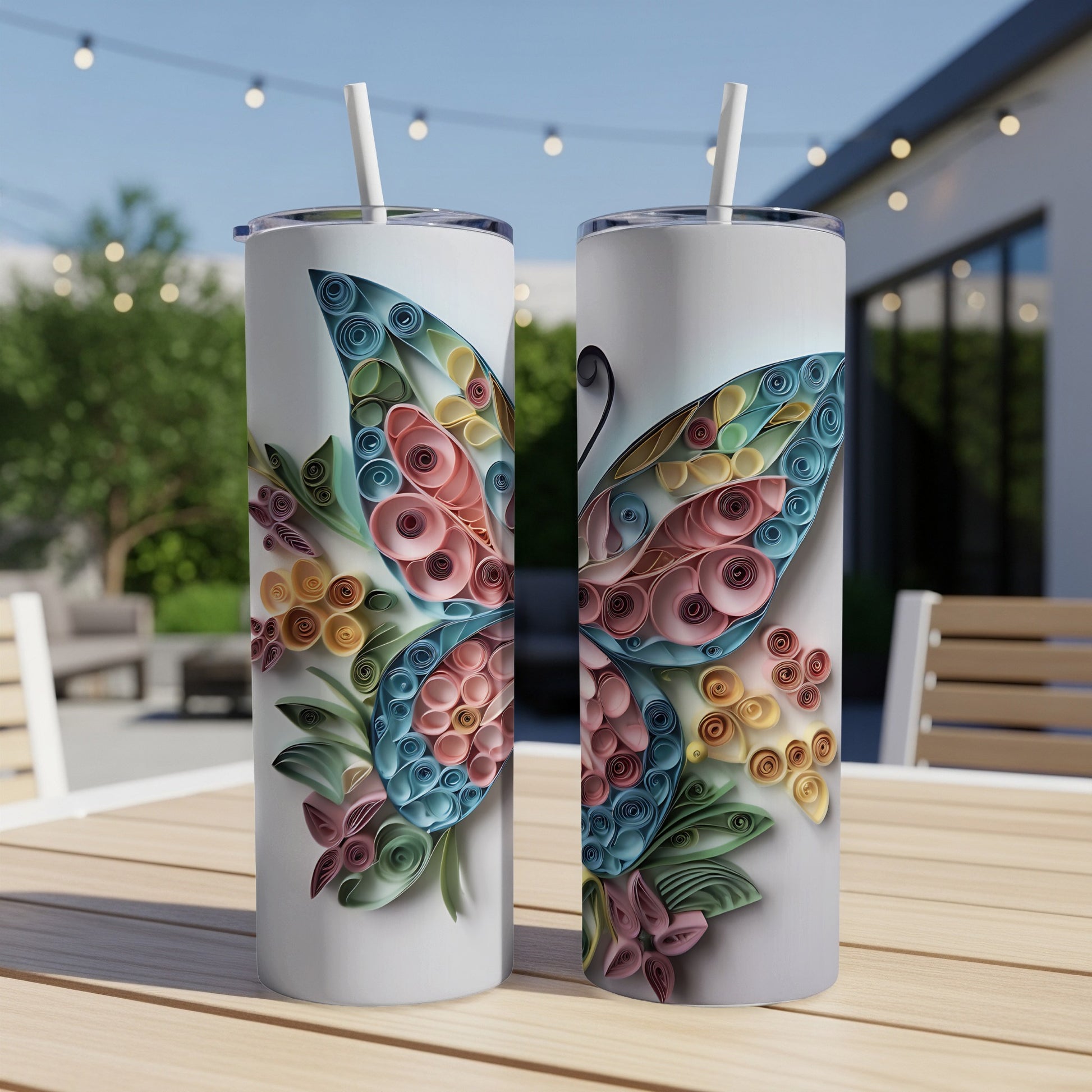 Two white tumblers with colorful paper quilled butterfly designs and straws.