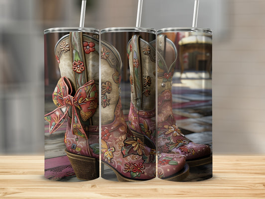 Cowboy boots adorned with floral embroidery and a bow, presented on a wooden surface.