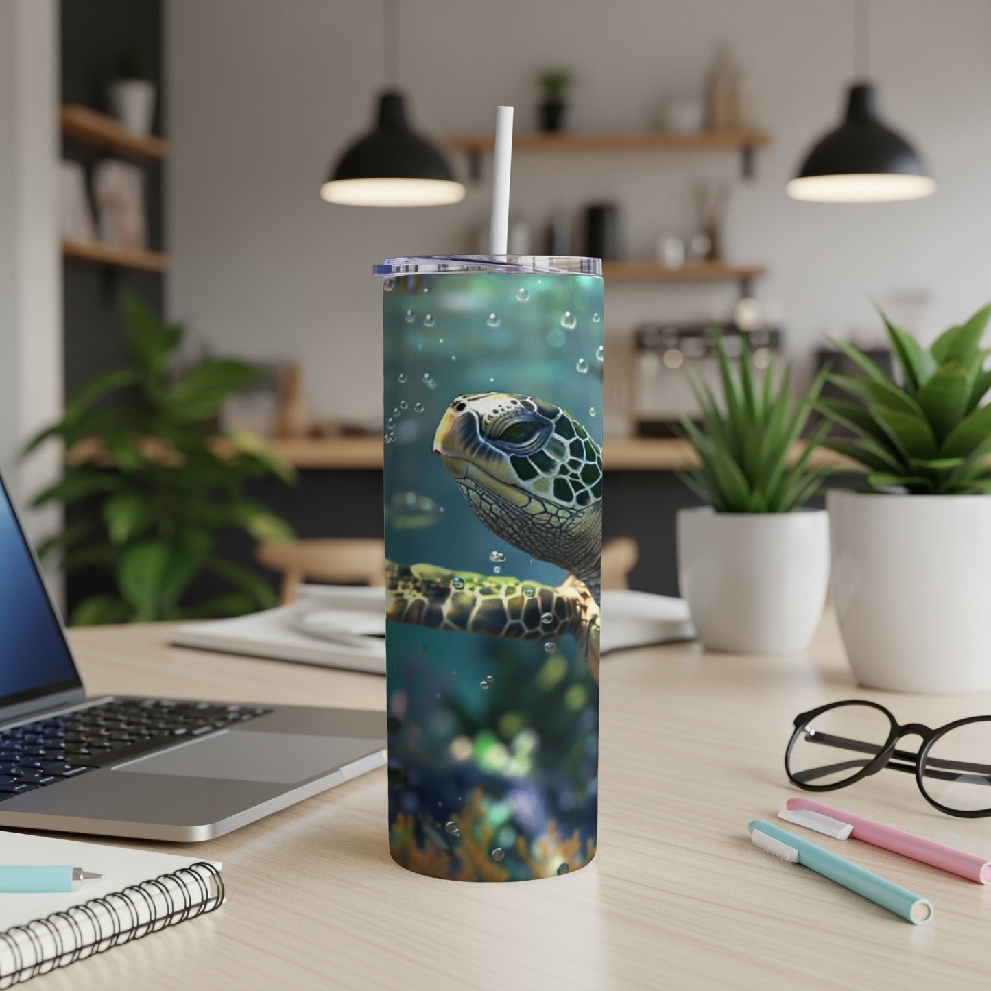 Sea turtle swimming underwater, surrounded by bubbles and coral, on a blue tumbler.