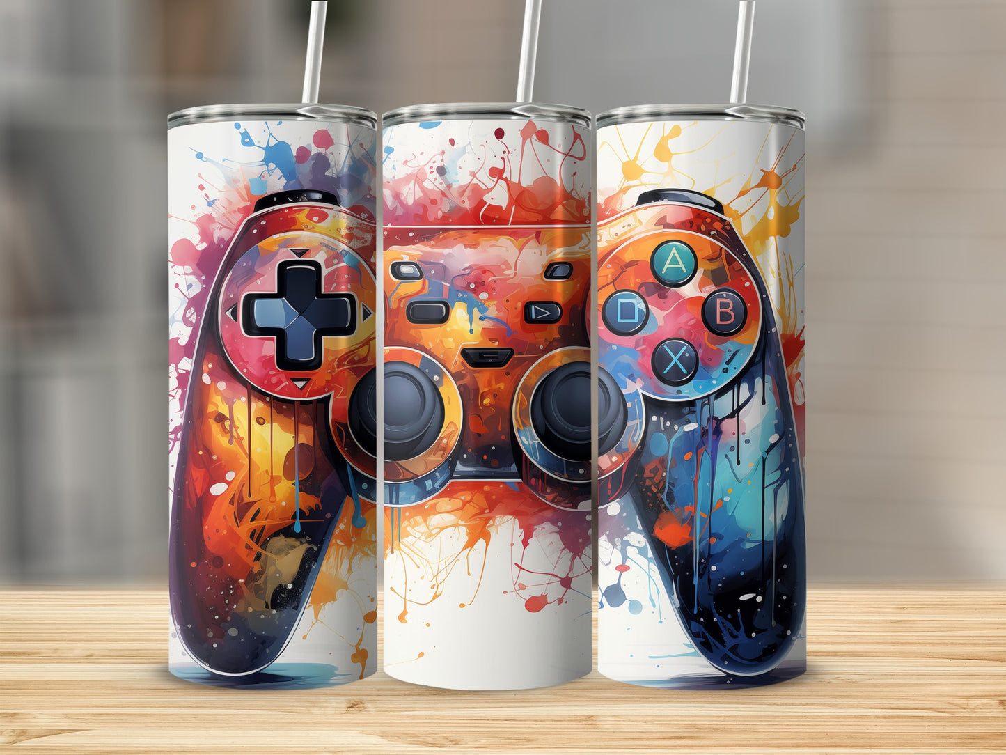 Three tumblers with vibrant video game controller design and colorful paint splatters.