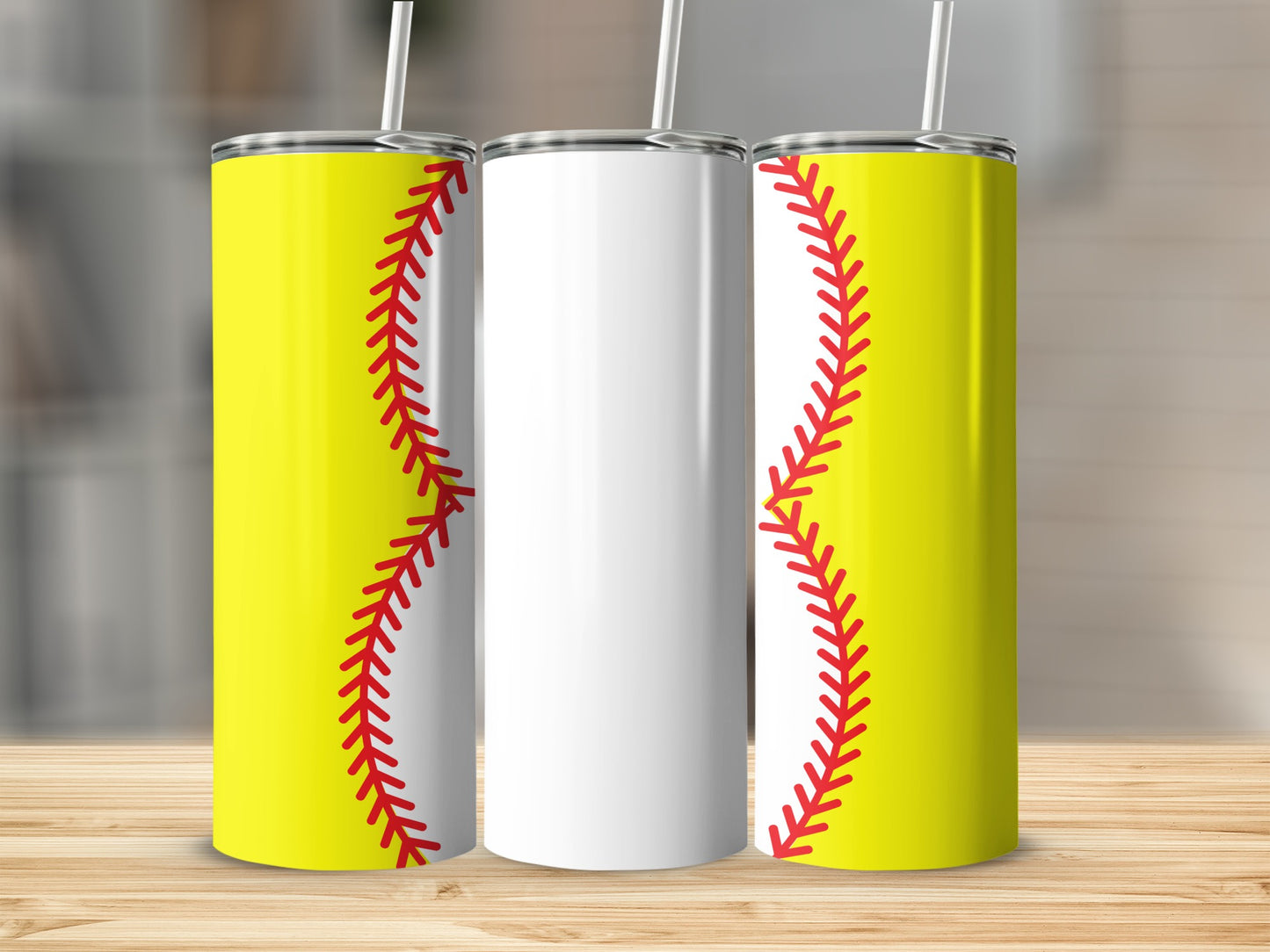 Three tumblers, two with yellow softball designs and one blank, on a wooden surface.