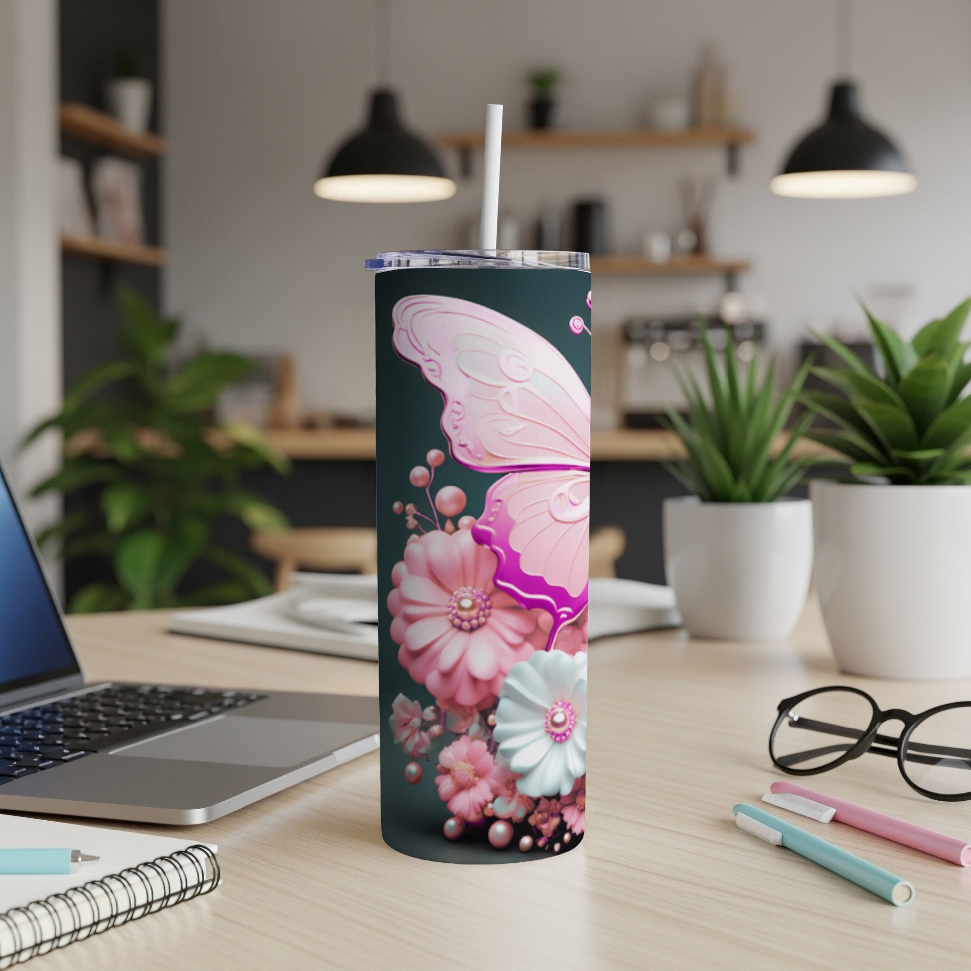 Pink butterfly and floral design on a dark green skinny tumbler.
