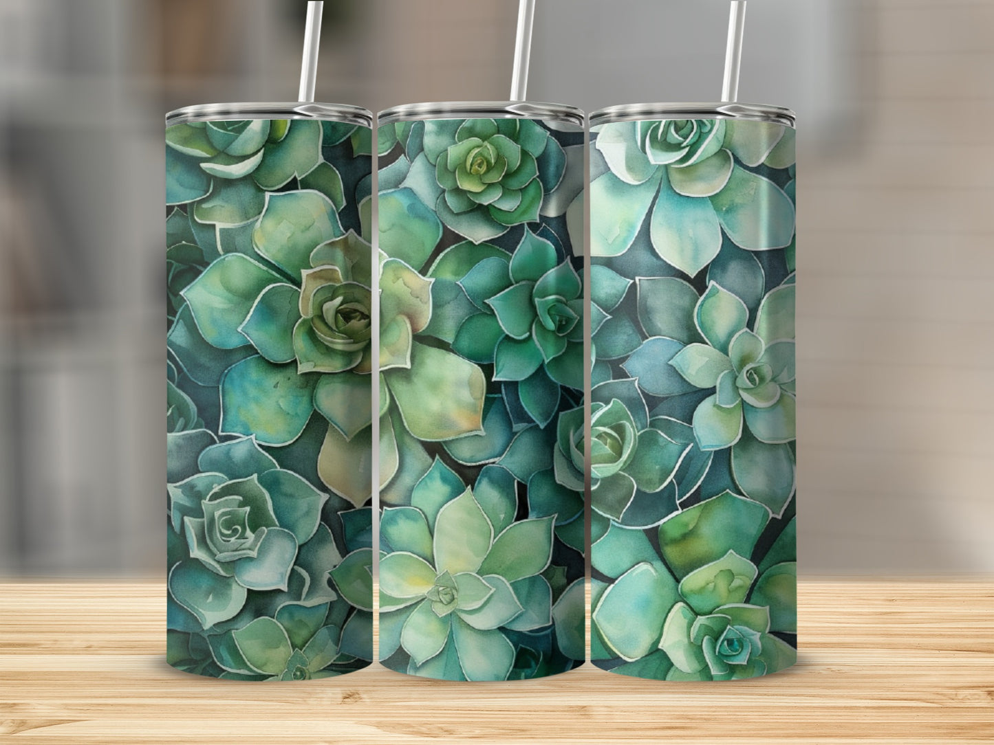 Three tumblers with a watercolor succulent pattern on a wooden surface.