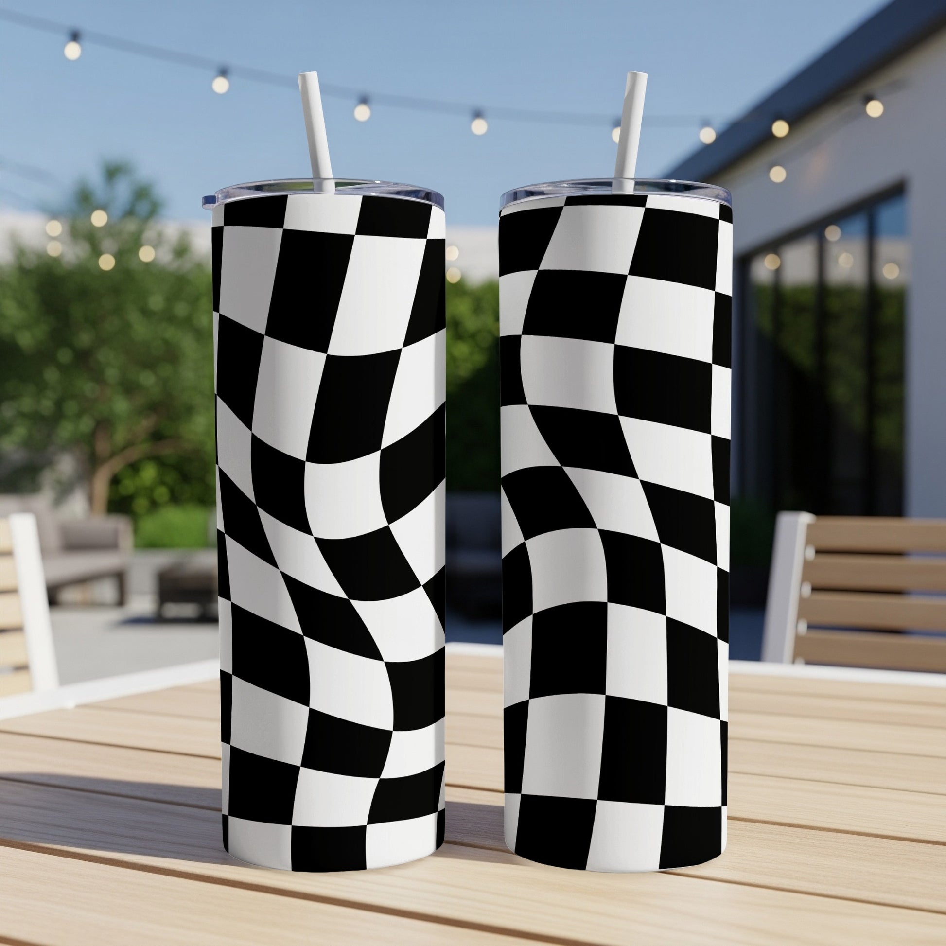 Two tumblers with a black and white checkered pattern on a wooden table.