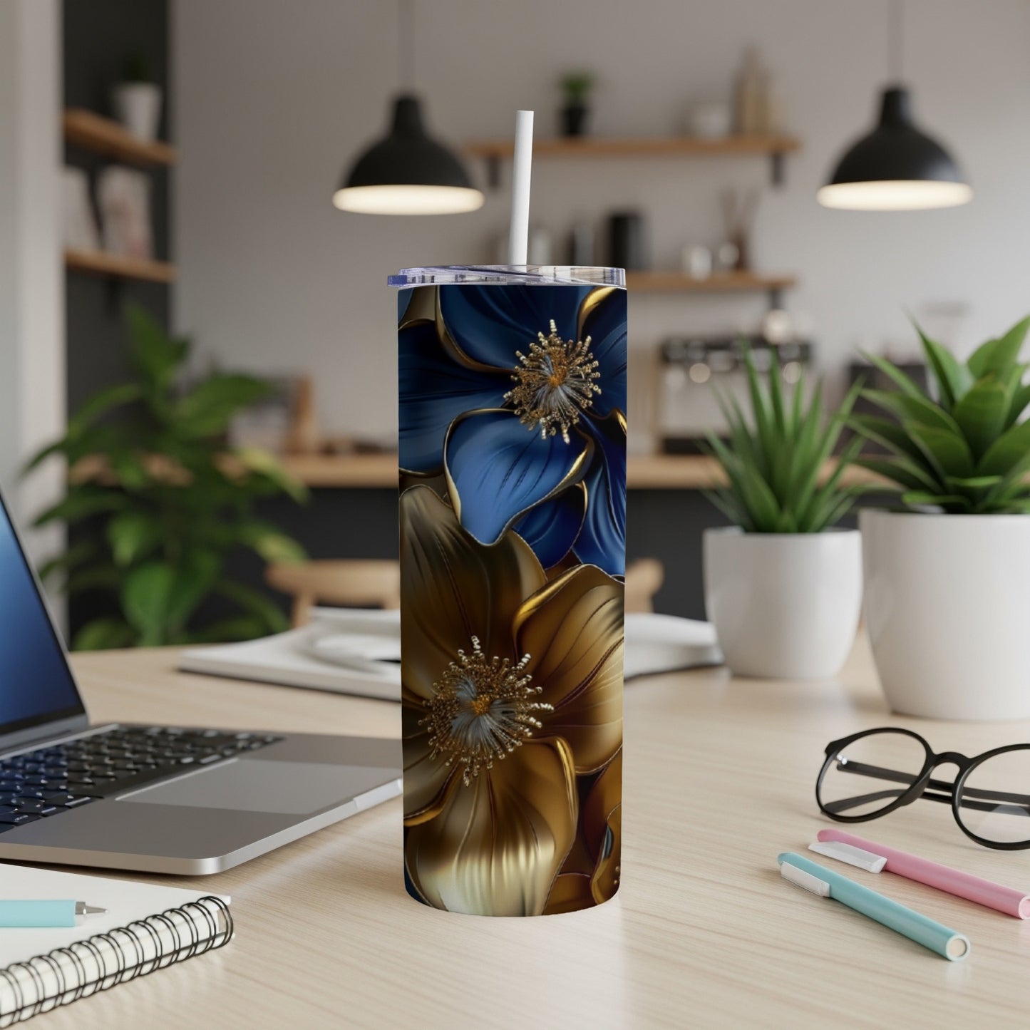 Gold and blue abstract floral pattern on a tall tumbler with a straw.