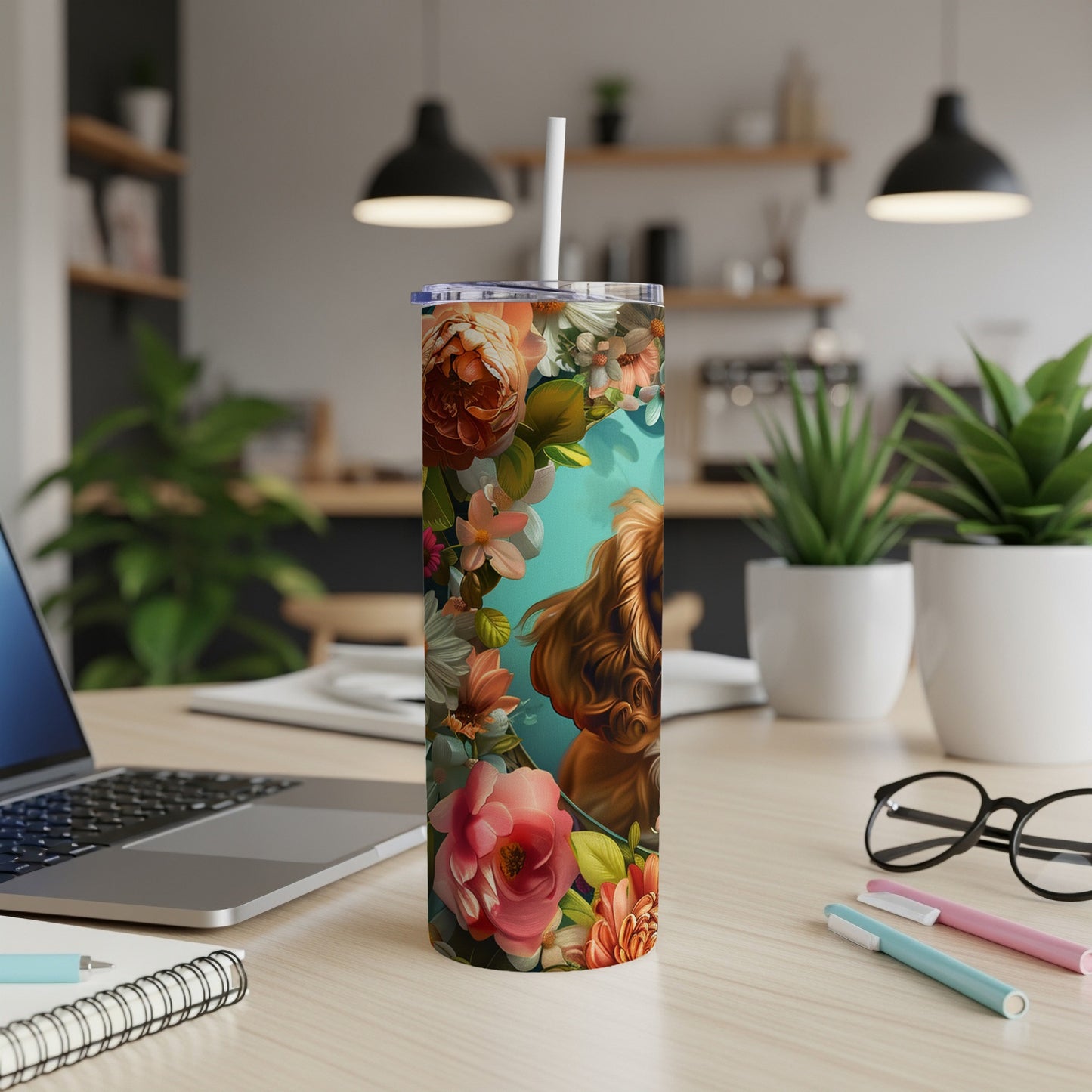 Floral pattern tumbler with dog artwork on a desk.