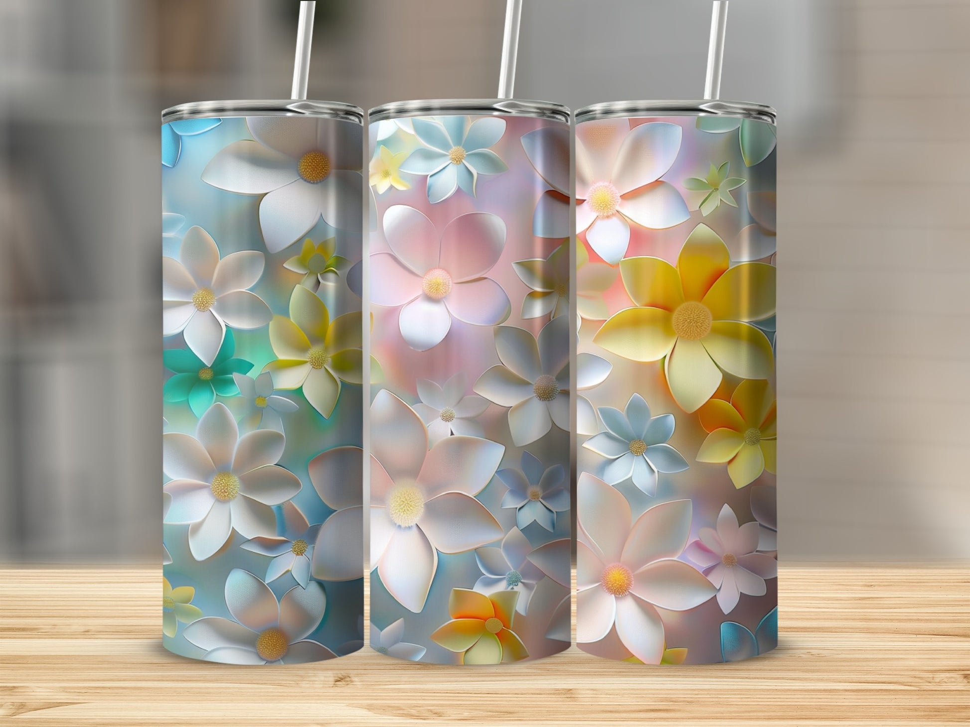 Three tumblers with pastel floral patterns stand on a wooden surface.