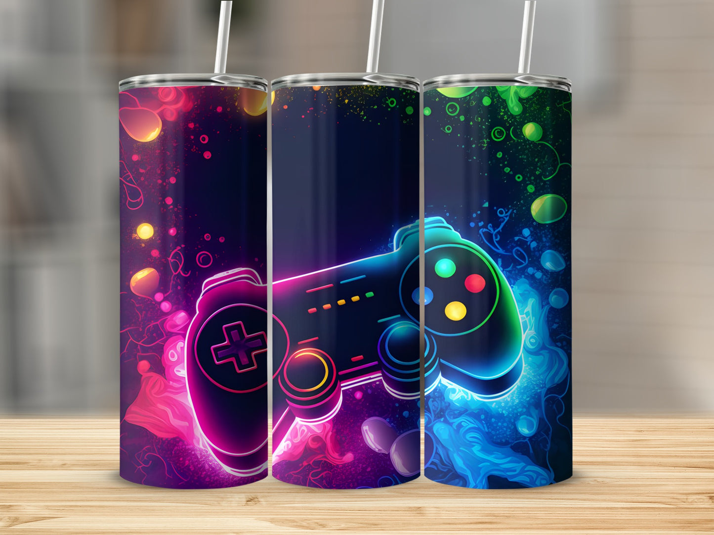 Three tumblers with neon gamer controller design, on a wooden surface.
