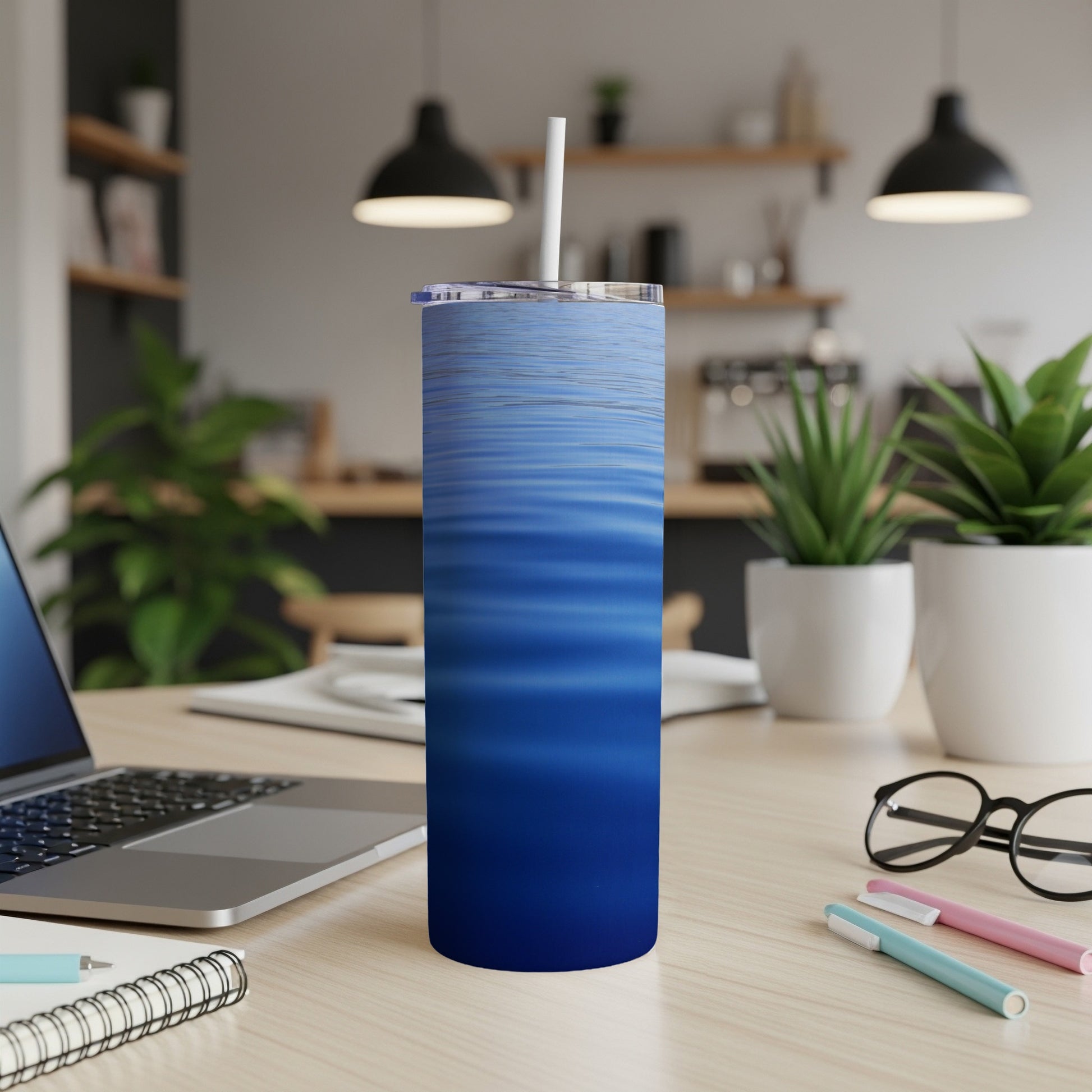 Blue wavy water pattern on a stainless steel tumbler with a straw.