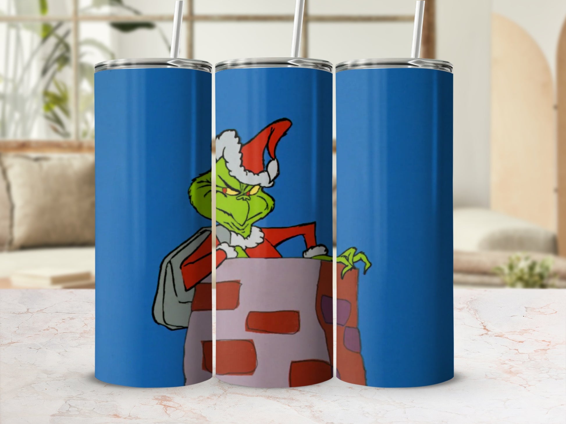 The Grinch wearing a Santa hat climbs out of a chimney bag on a blue tumbler.