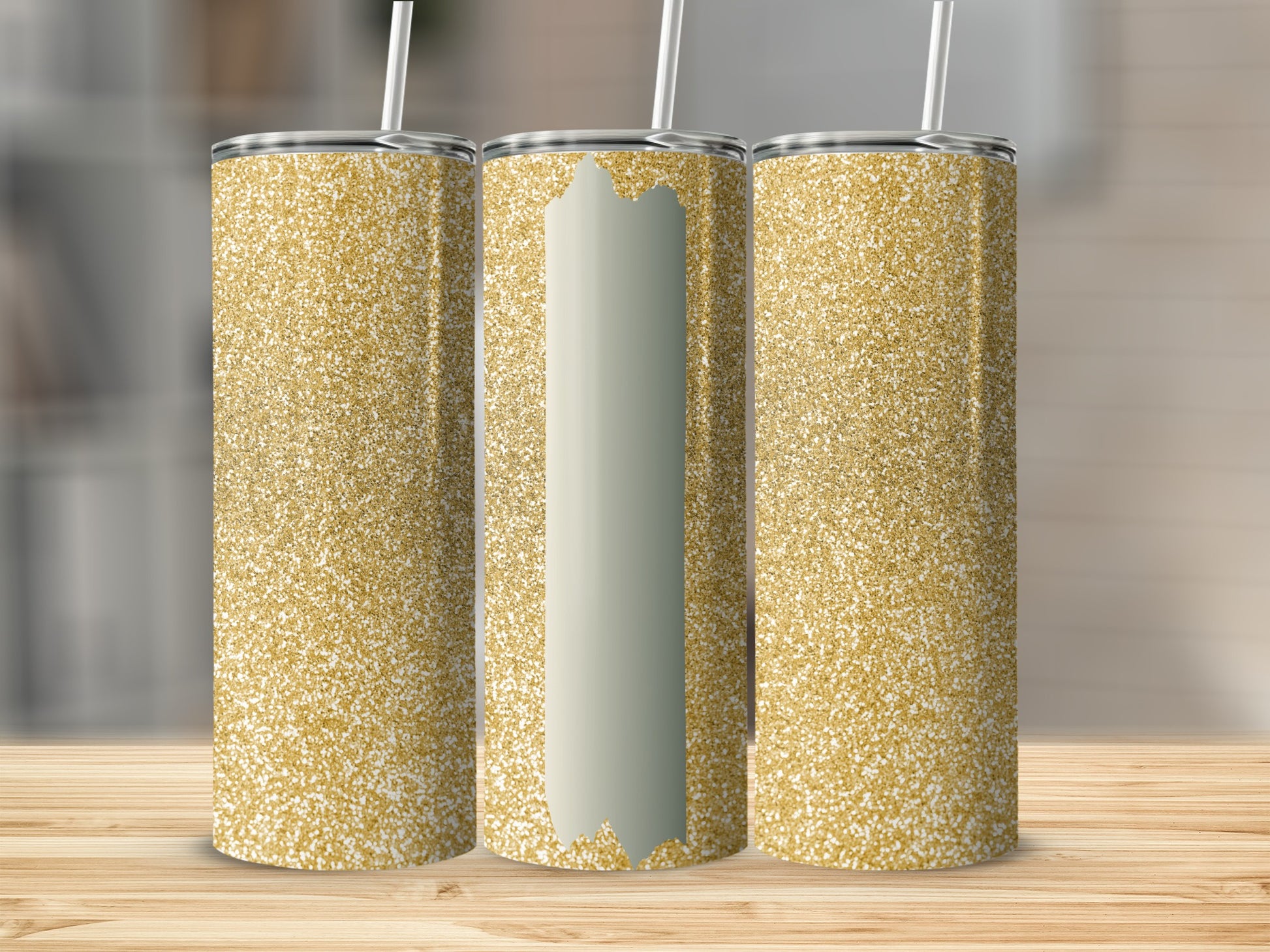 Three glittery gold tumblers with straws on a wooden surface.