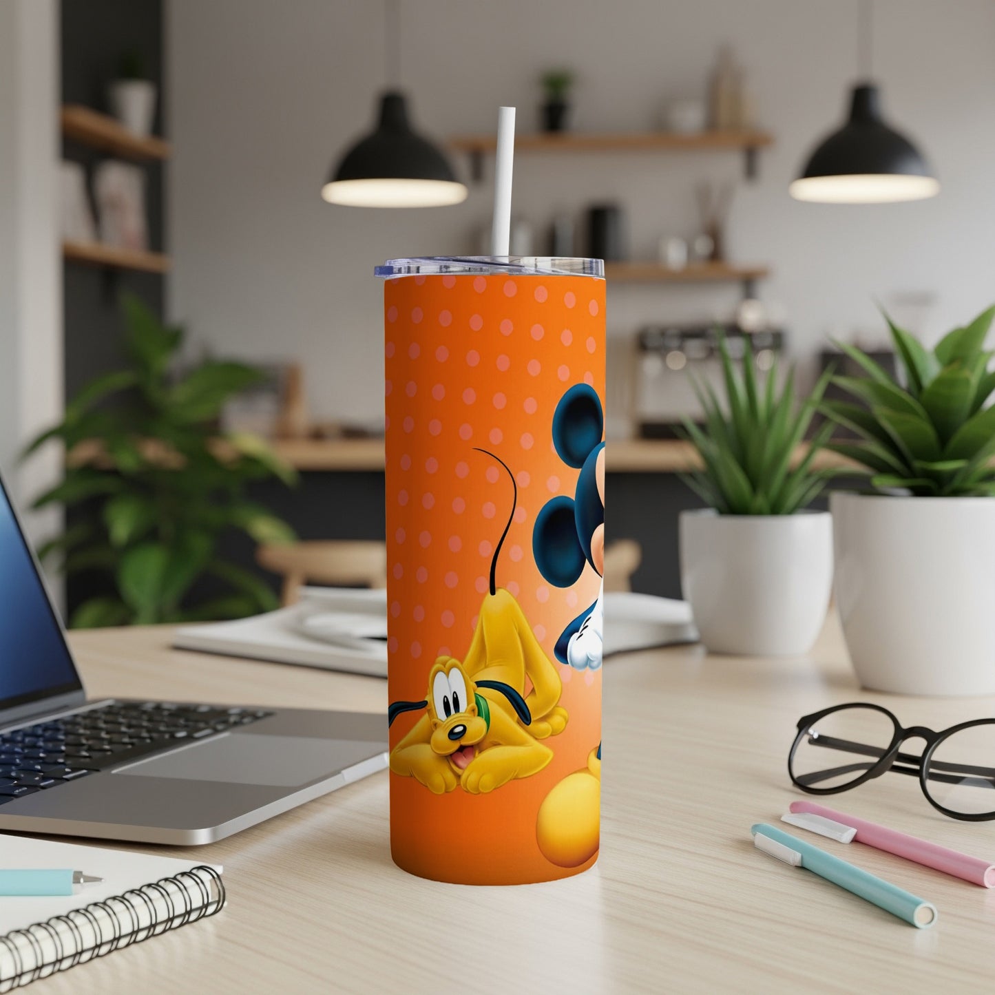 Orange tumbler with Mickey Mouse and Pluto illustration and white polka dots.