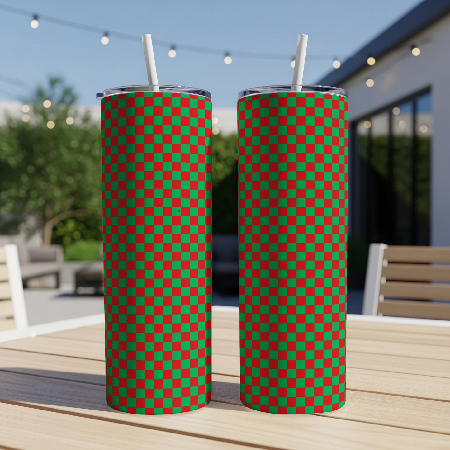 Two tall tumblers with a red and green checkered pattern, each with a white straw.