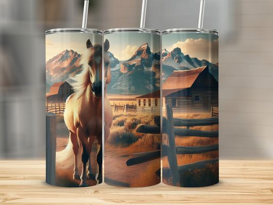 Tan horse in a barnyard with mountains in the background.