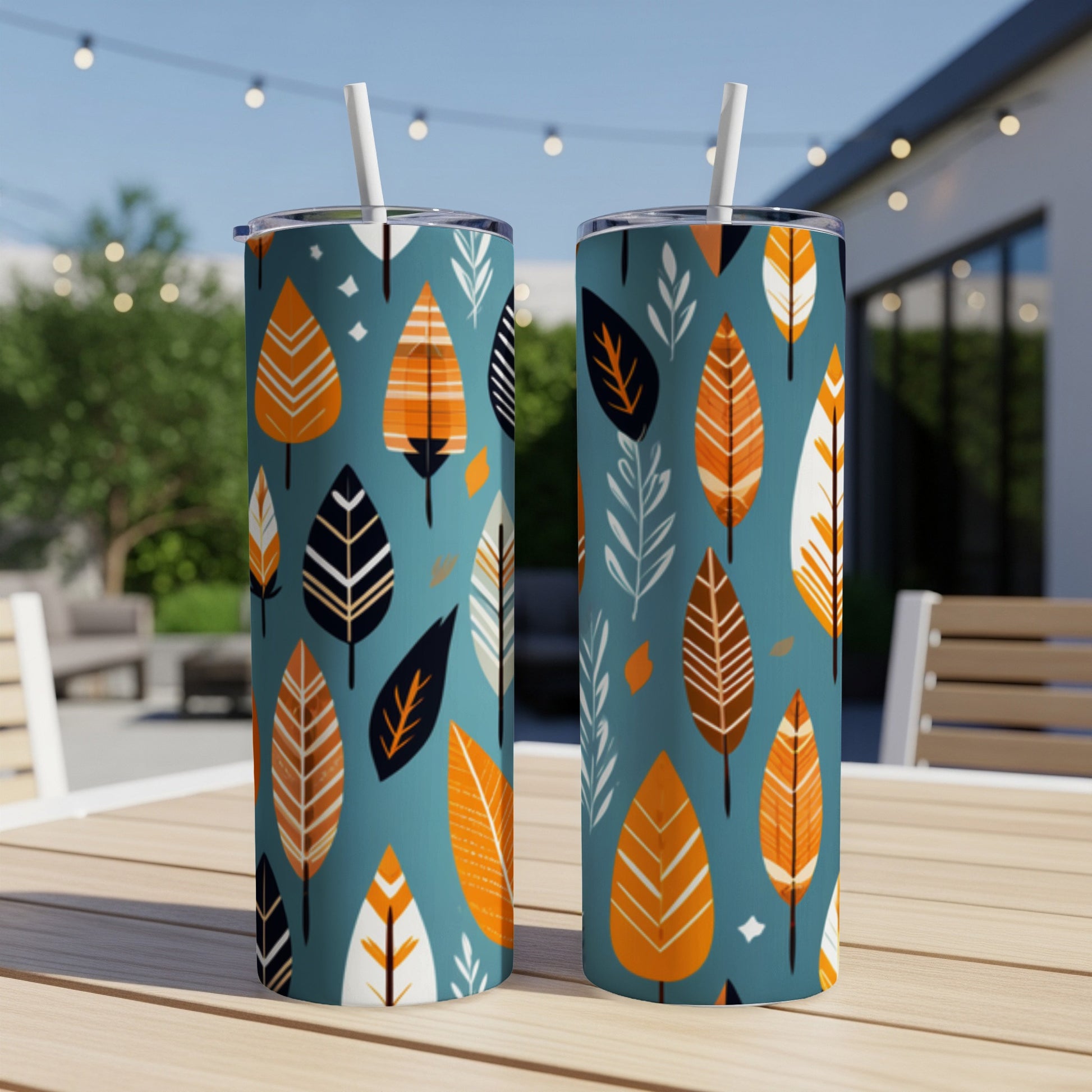 Two teal tumblers with a repeating pattern of orange and white leaves.