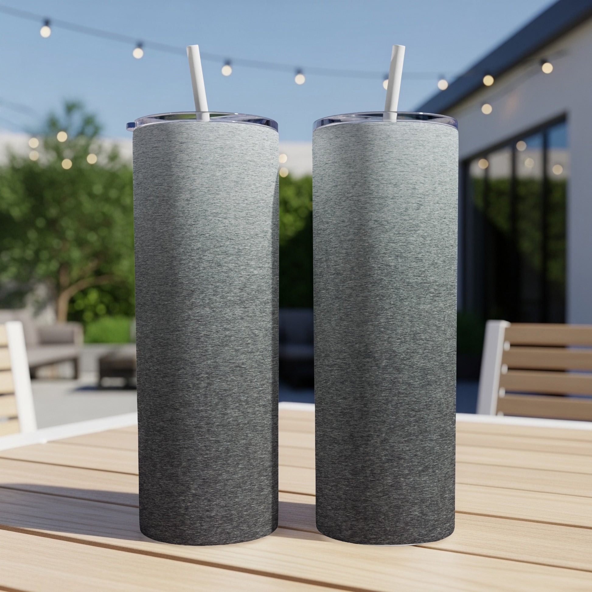 Two tall stainless steel tumblers with gradient gray and black finish, on table.
