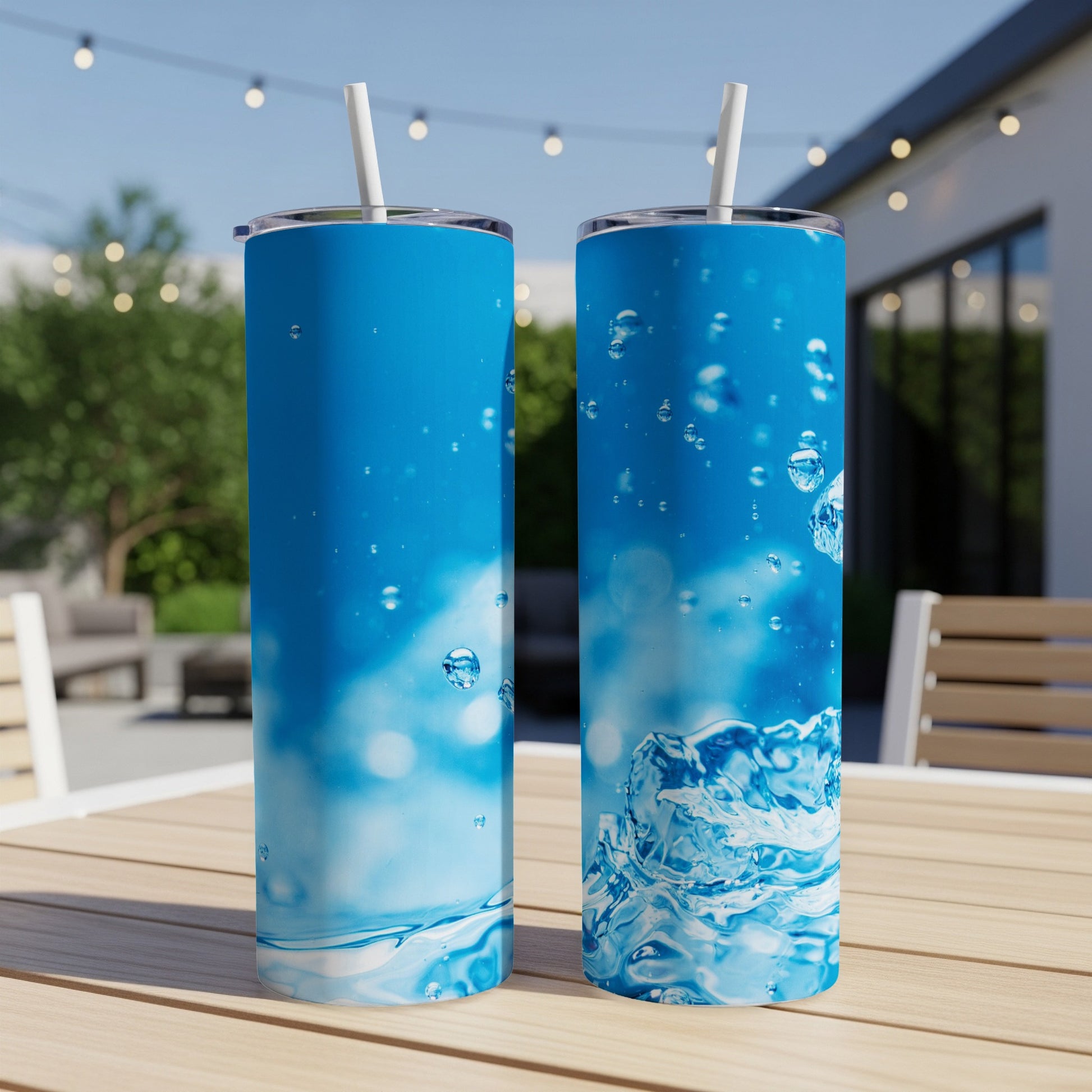 Two blue tumblers with water splash and bubble graphics on a wooden table.