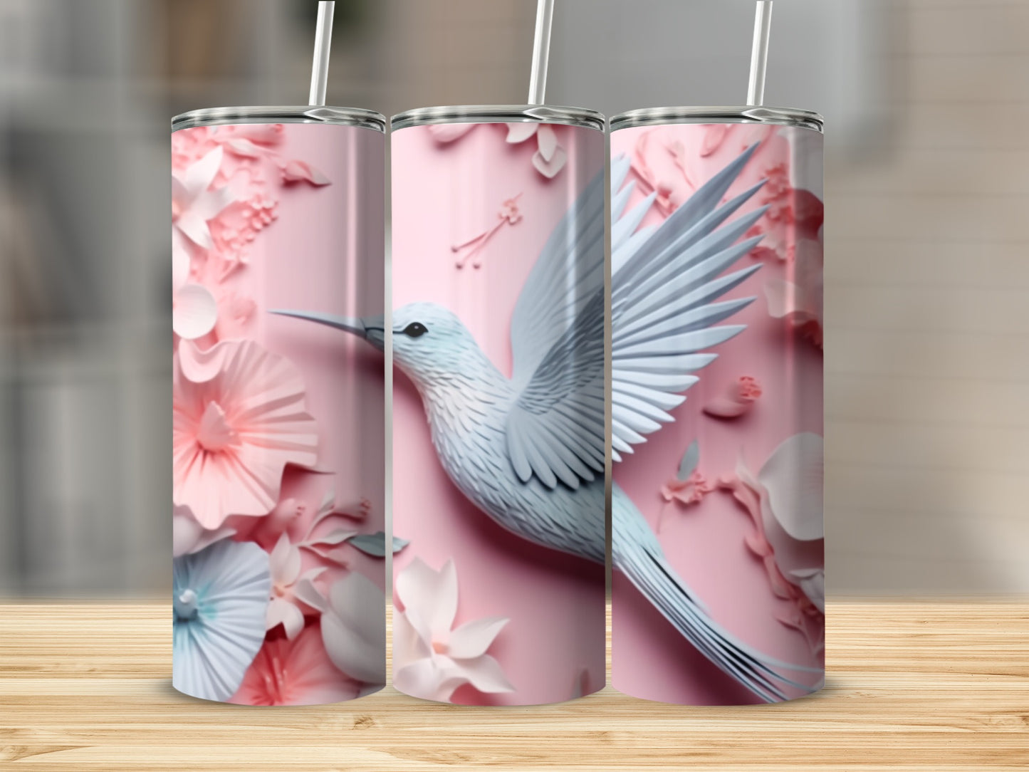 Pink tumbler with a white hummingbird and floral embellishments.