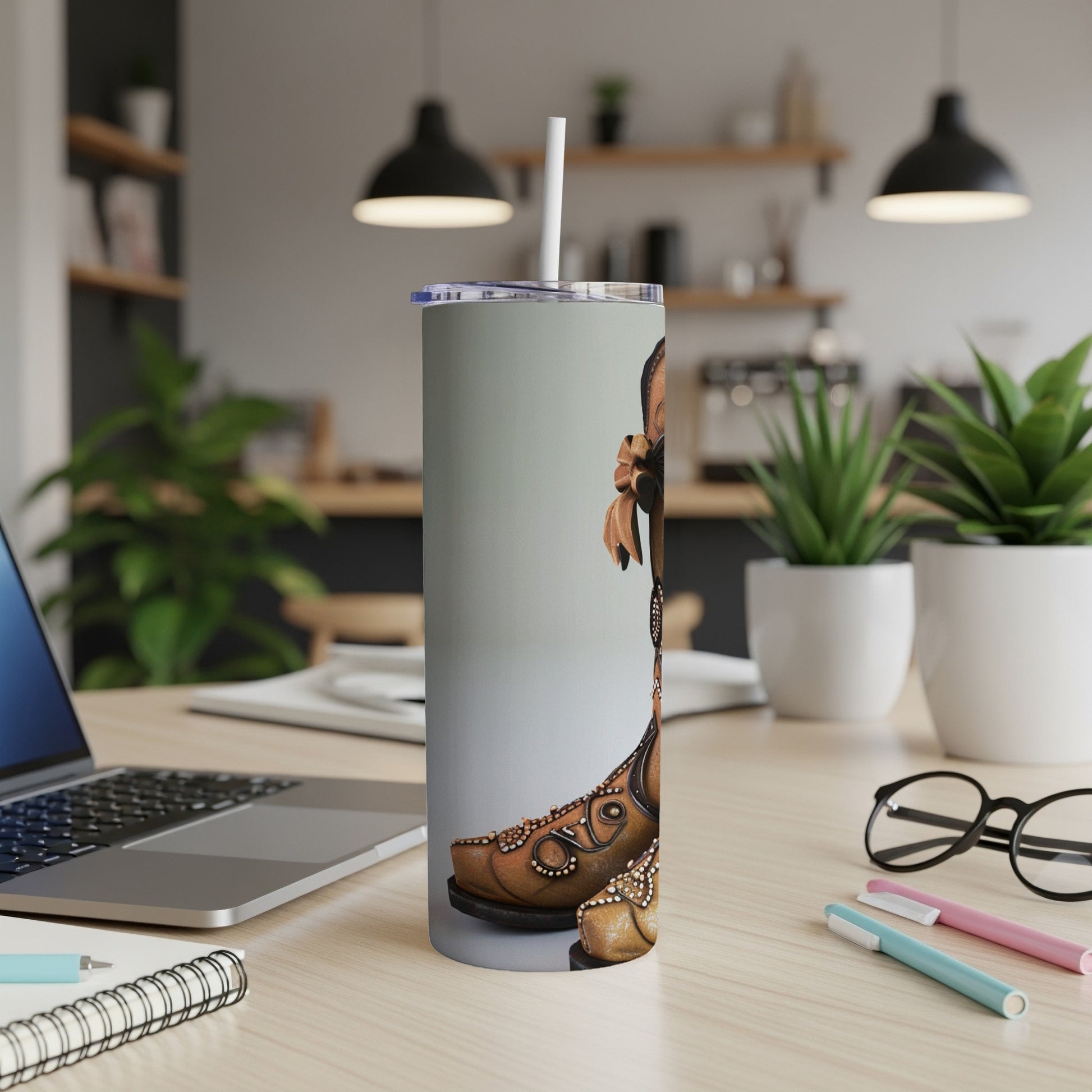 Brown cowboy boot design on a silver tumbler with a straw.