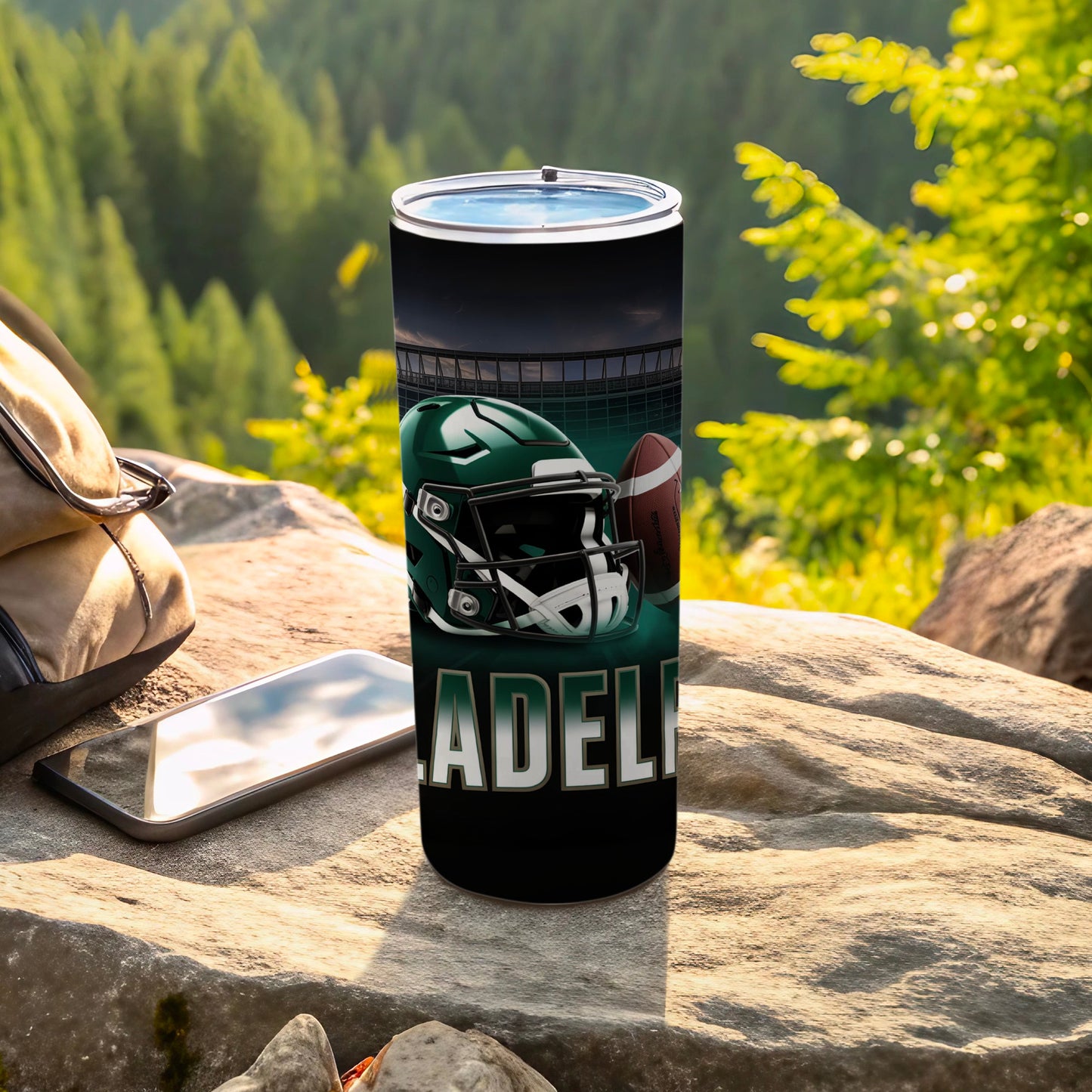 Green football helmet and ball on a tumbler with "ADELPHIA" text.