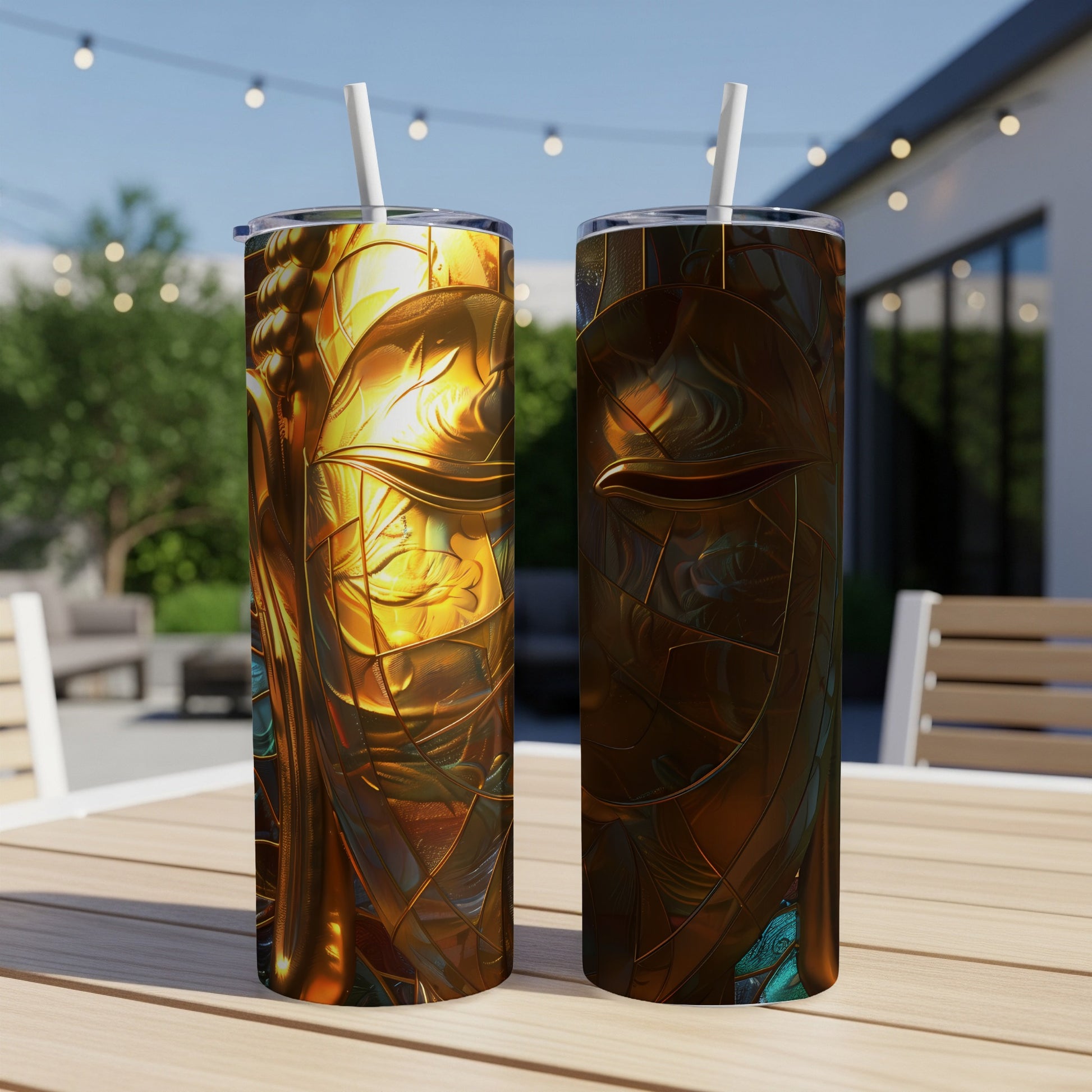 Two tumblers with a stained-glass style Buddha face design on a table.