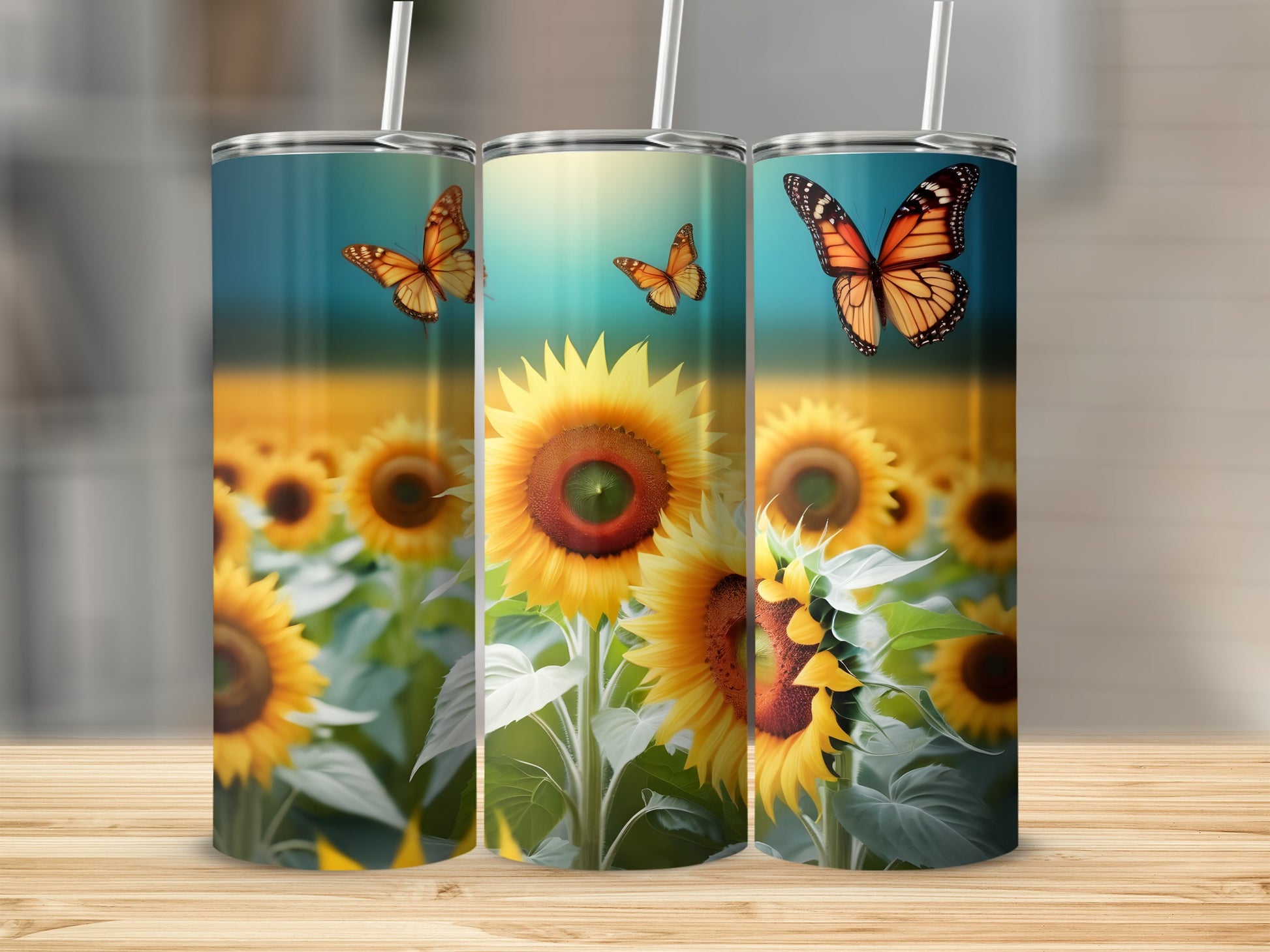 Three tumblers with sunflowers and butterflies against a blurred field of sunflowers.