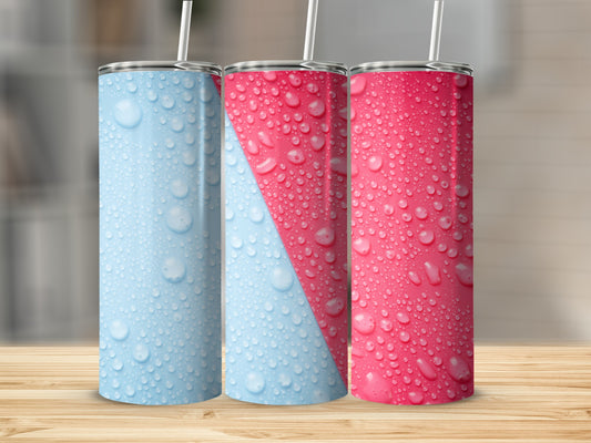 Three tumblers with water droplet patterns in blue and pink on a wooden surface.