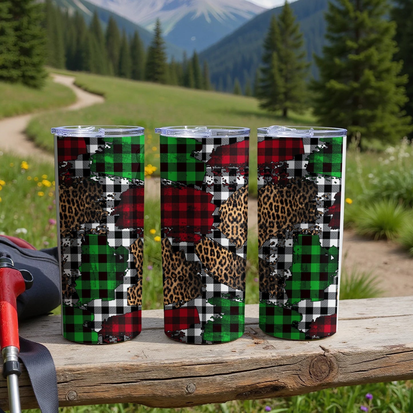 Three tumblers with plaid and leopard print designs on a wooden surface.