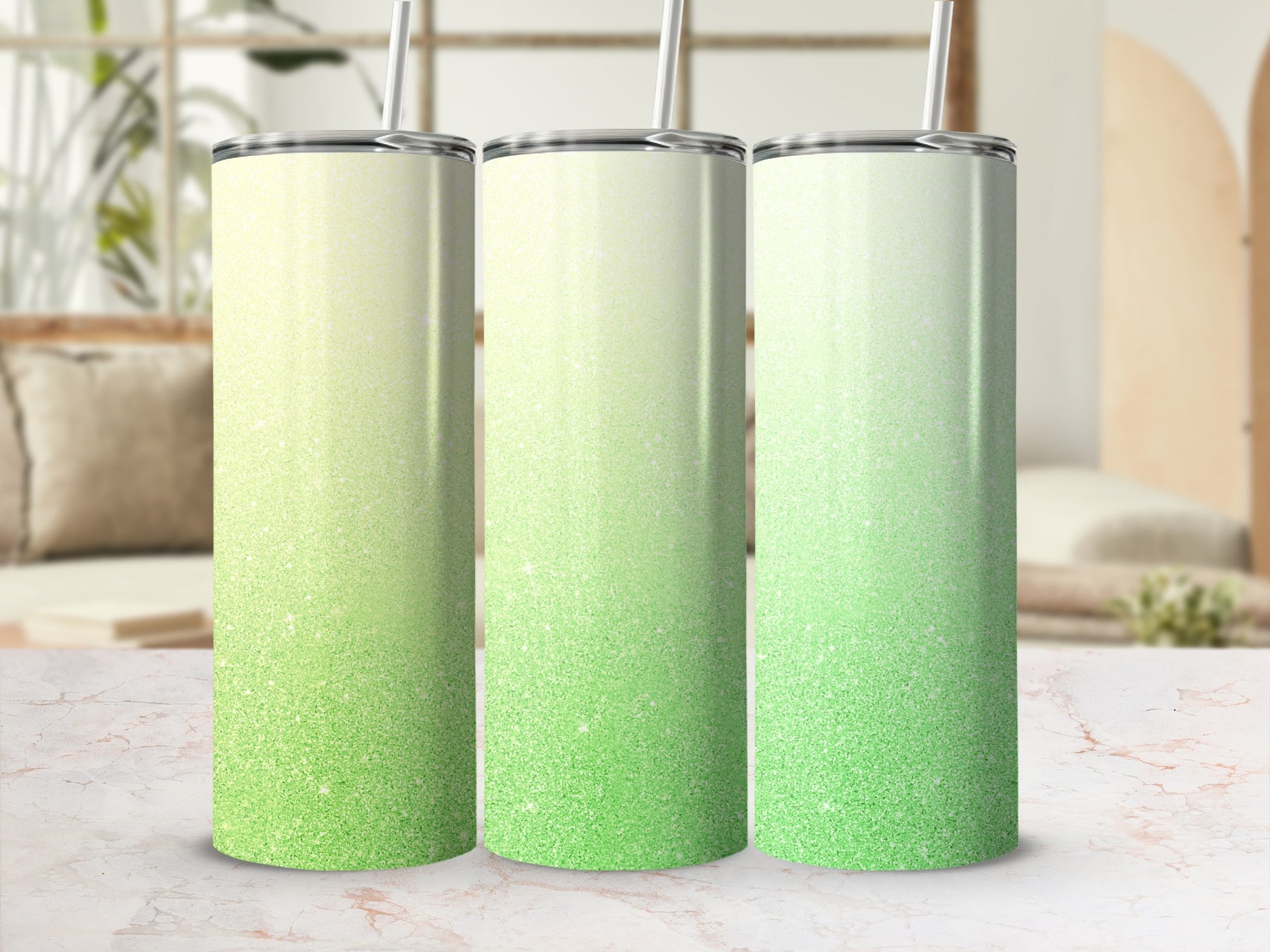 Three tumblers with green glitter ombre design and straws.