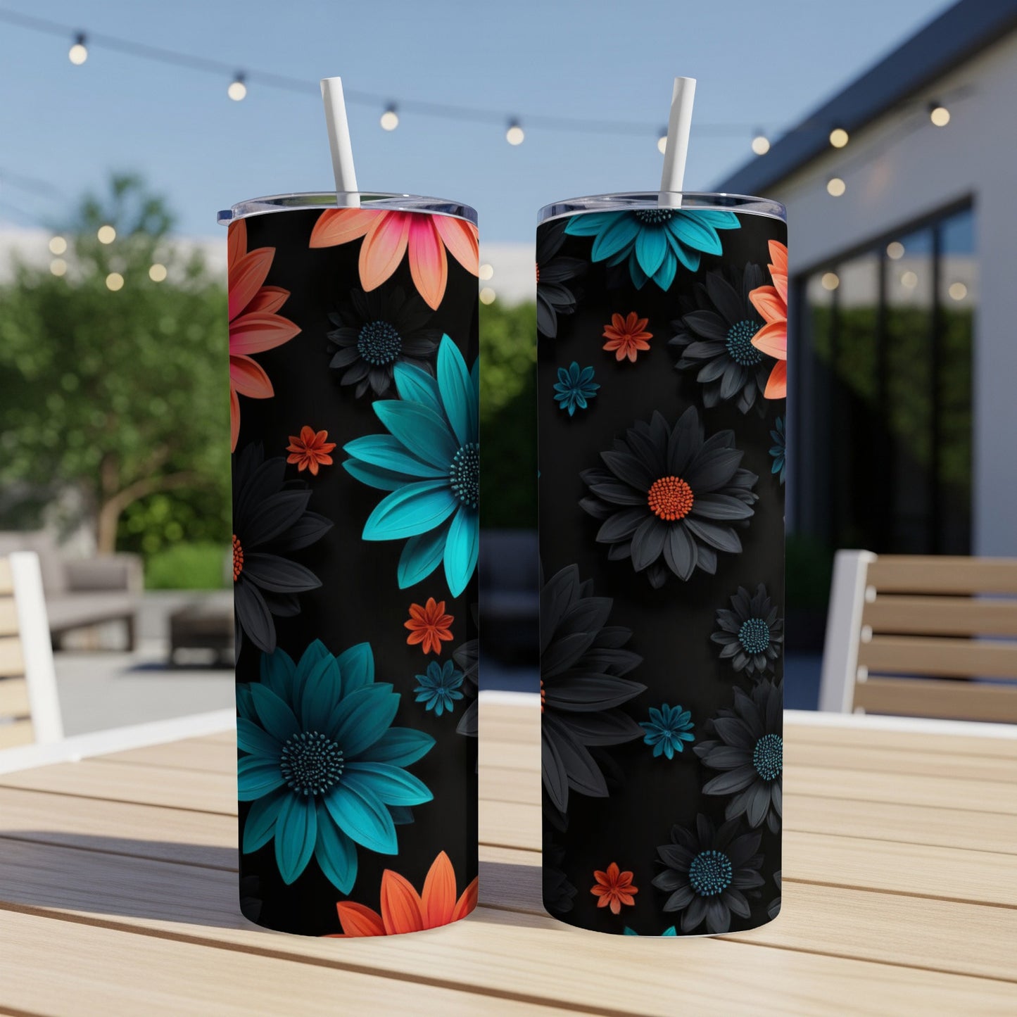 Two black tumblers with colorful floral patterns on an outdoor table.