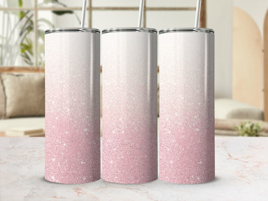Three skinny tumblers with pink glitter gradient and straws, on a marble surface.