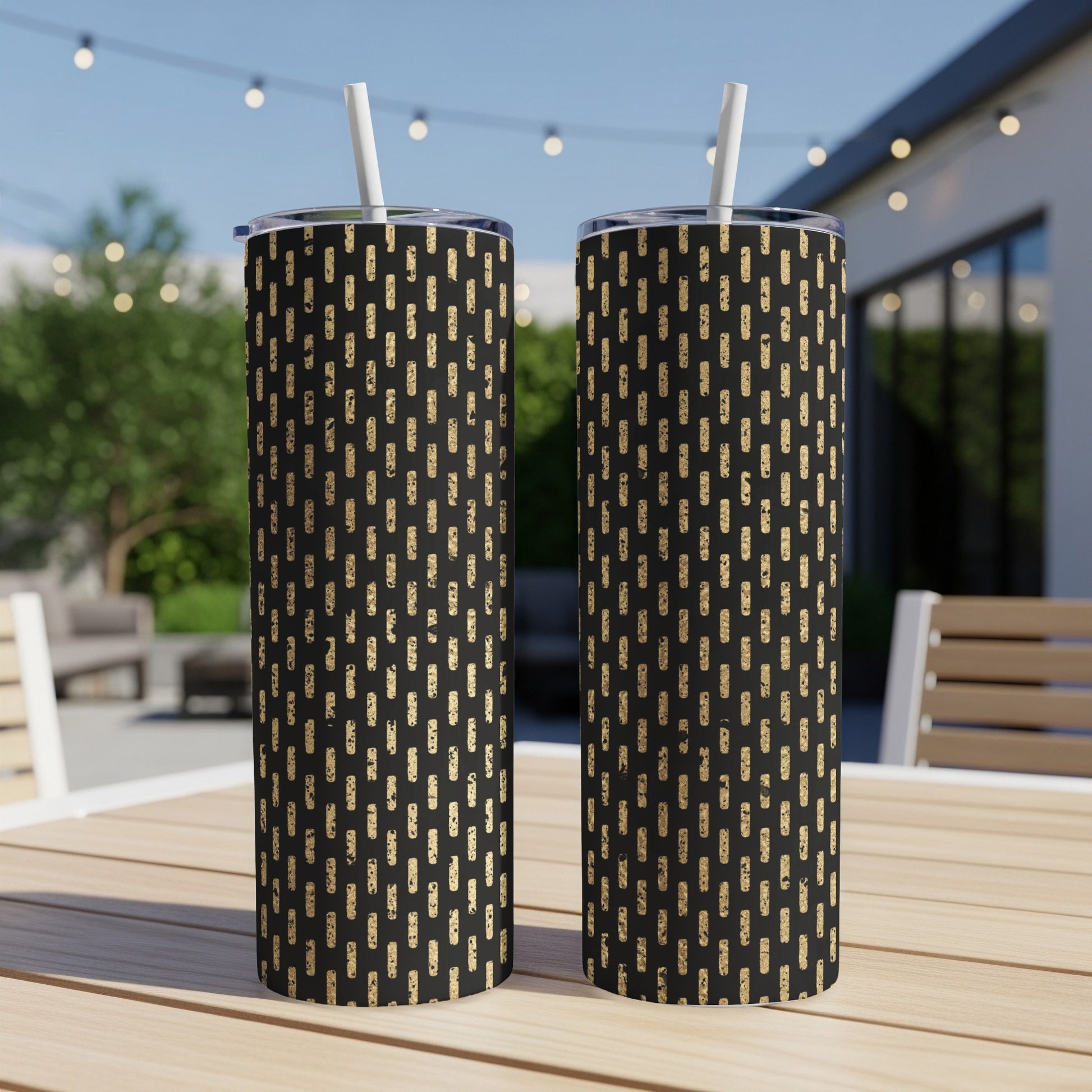 Two black tumblers with a speckled gold dash pattern, each with a straw.