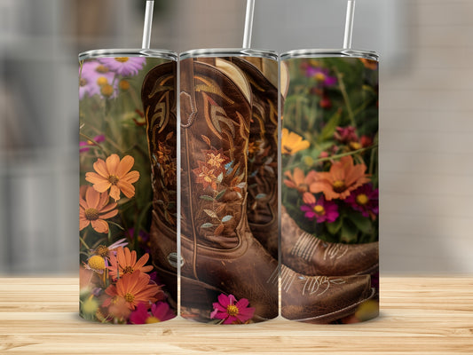 Brown cowboy boots with floral embroidery surrounded by colorful flowers.