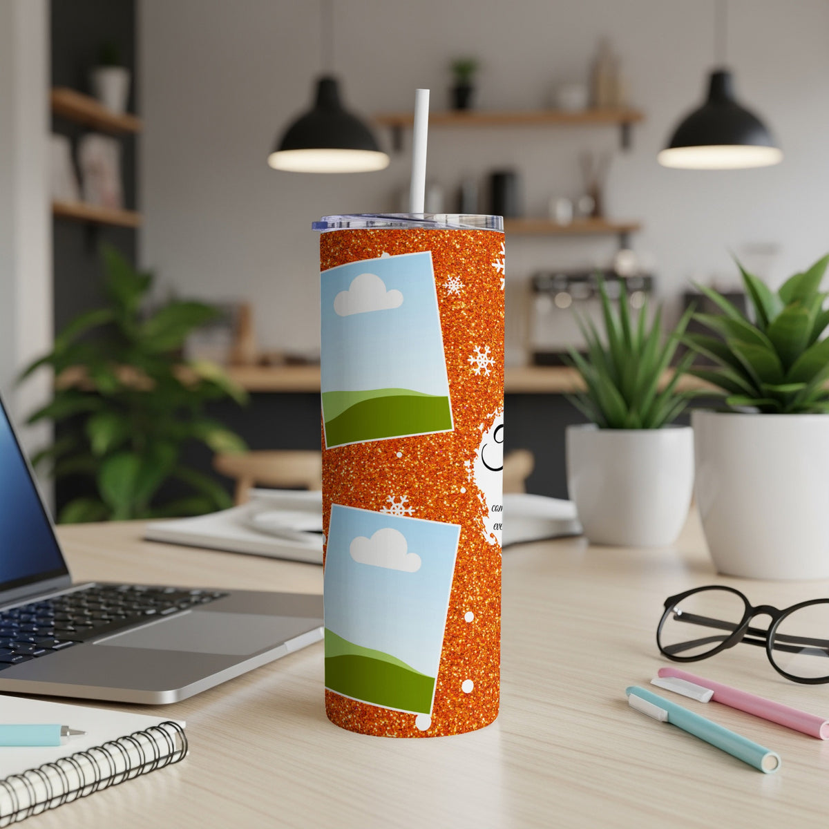 Orange glitter tumbler with photo placeholders, snowflakes, and text on a desk.
