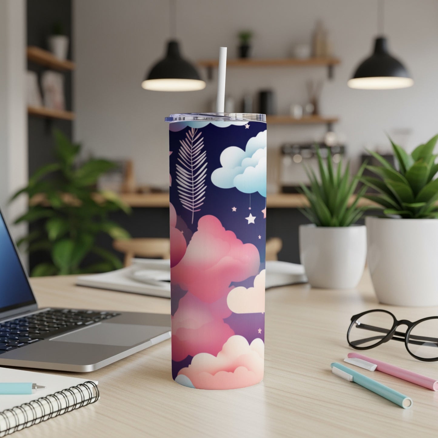 Tall, skinny tumbler with a cloud and feather pattern on a desk.