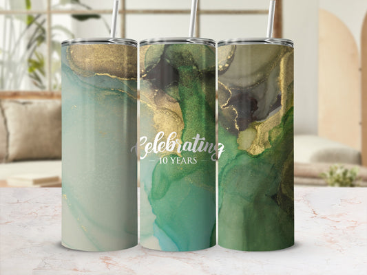 Three tumblers with marbled green and gold abstract design, one says "Celebrating 10 Years".