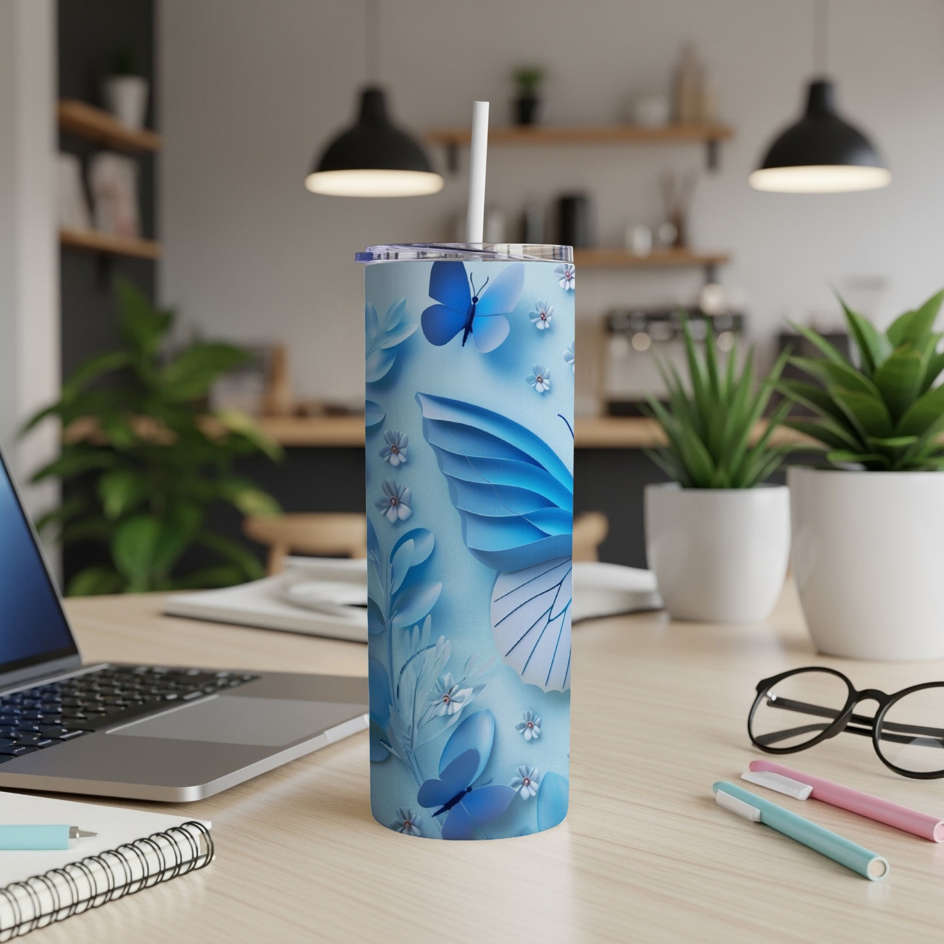 Blue butterfly tumbler with straw on a desk.