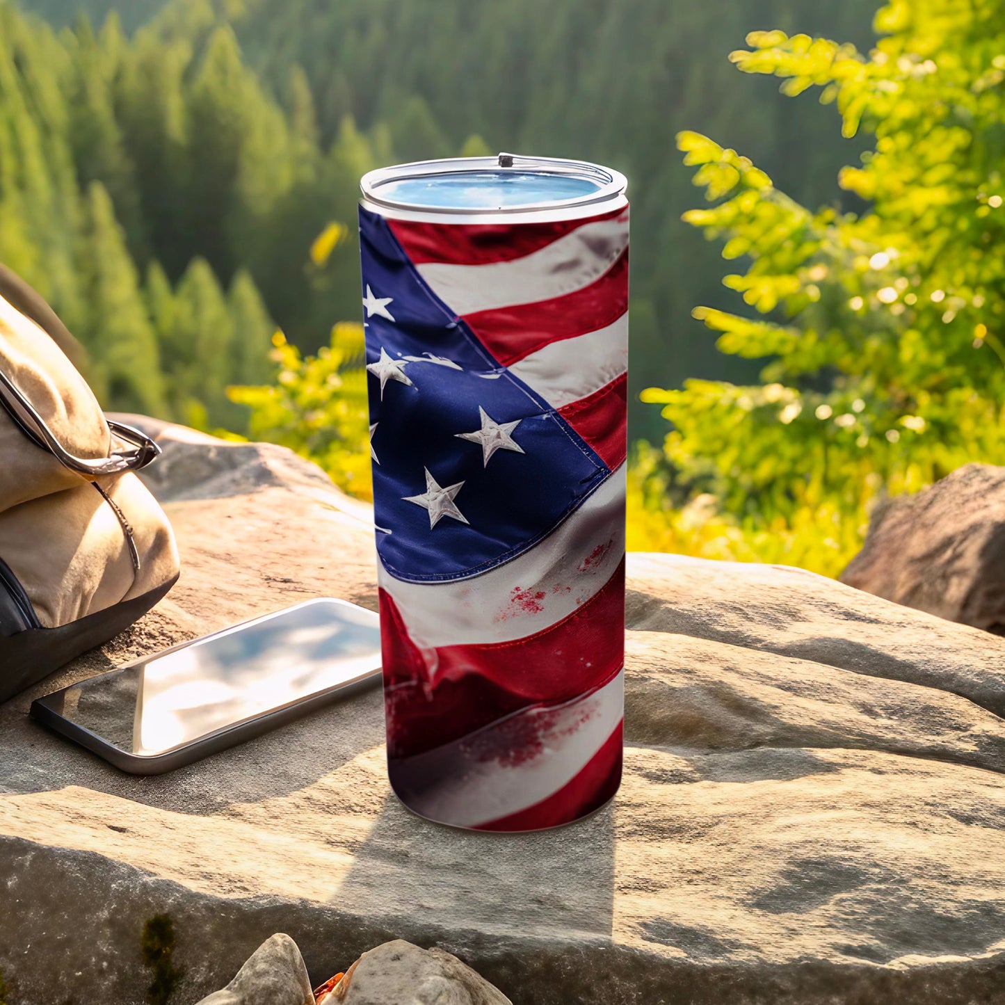Tumbler with American flag design on a rock outdoors.