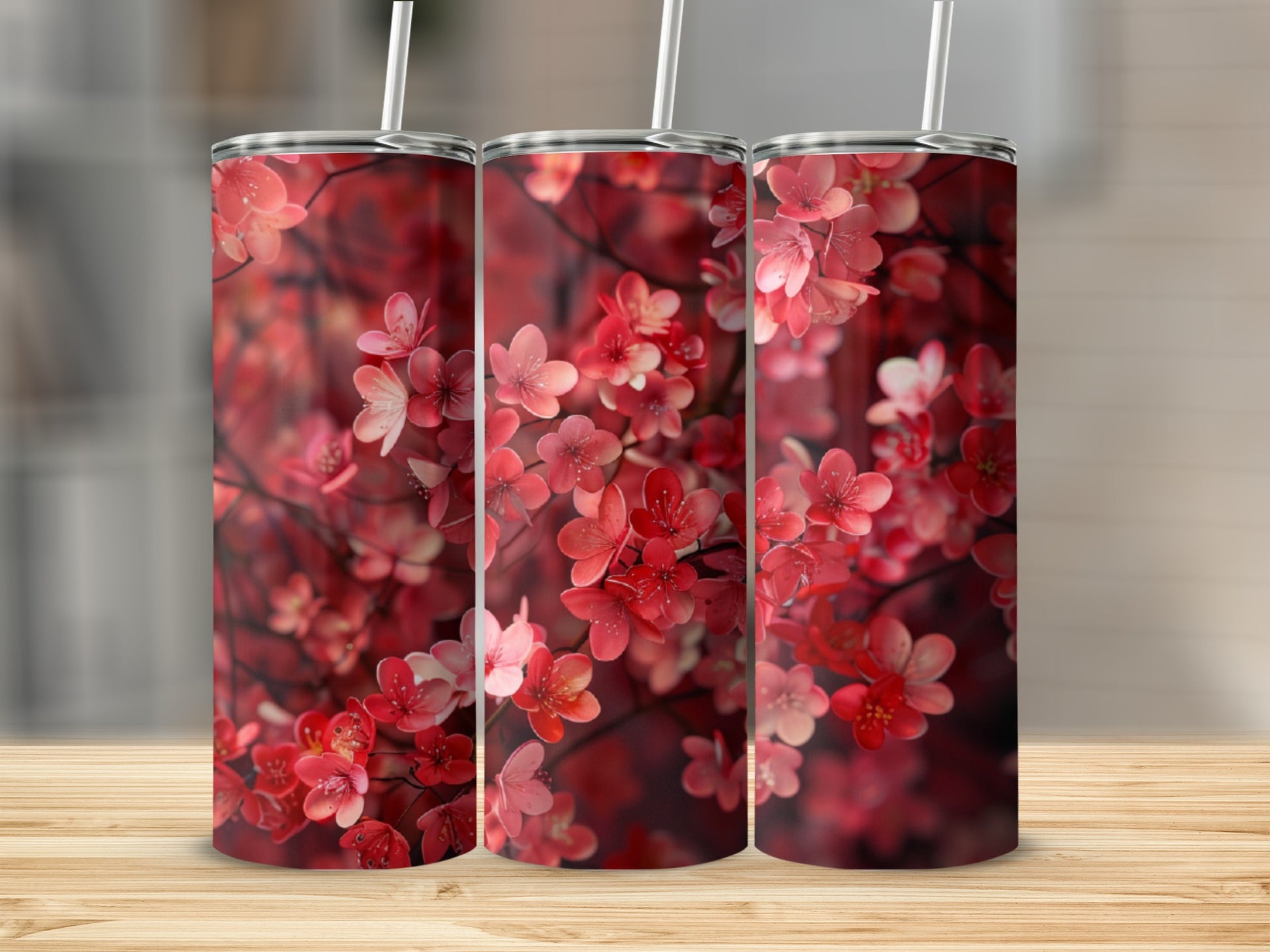 Three tumblers with a floral pattern of pink and red blossoms.