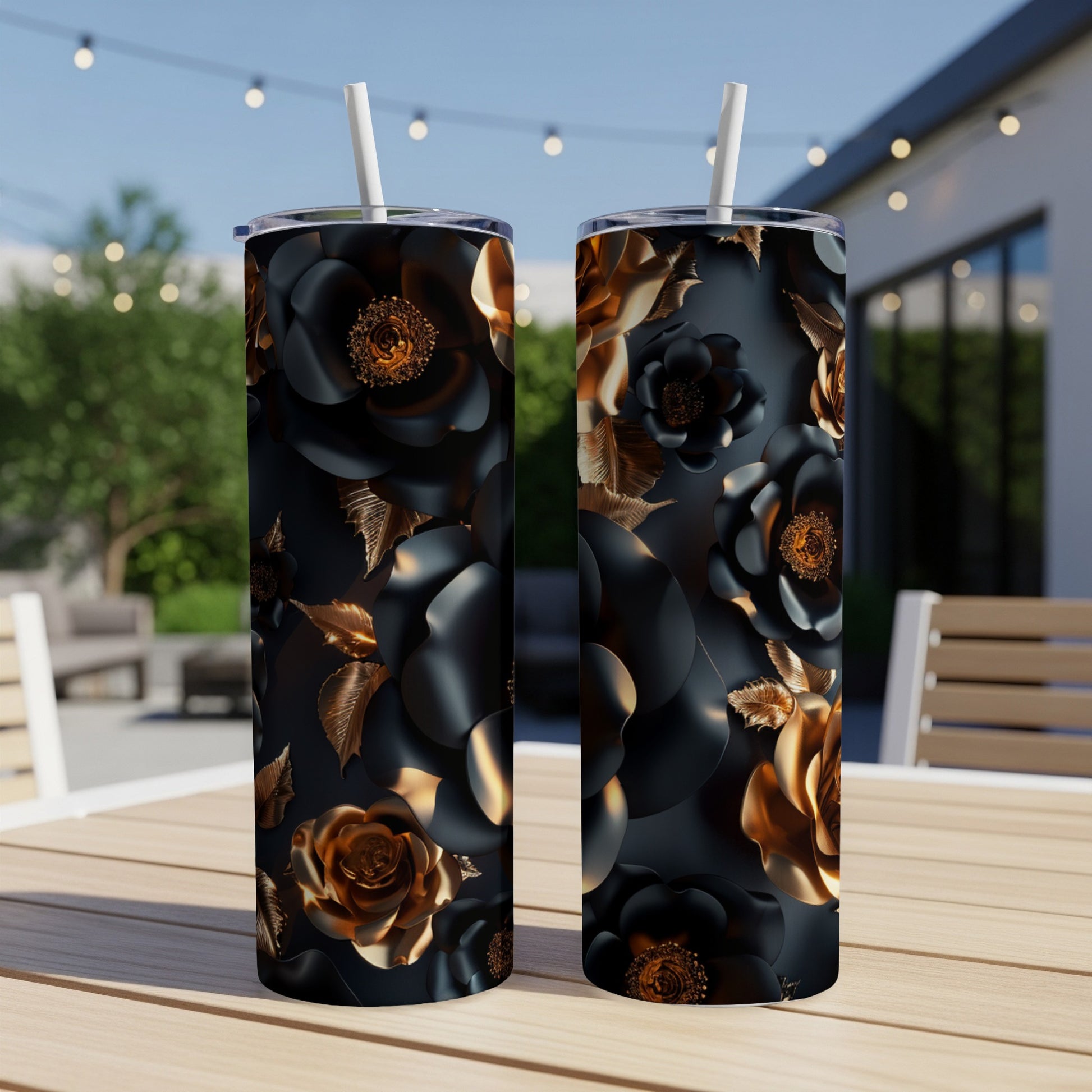 Two black tumblers with gold floral accents sit on a table.