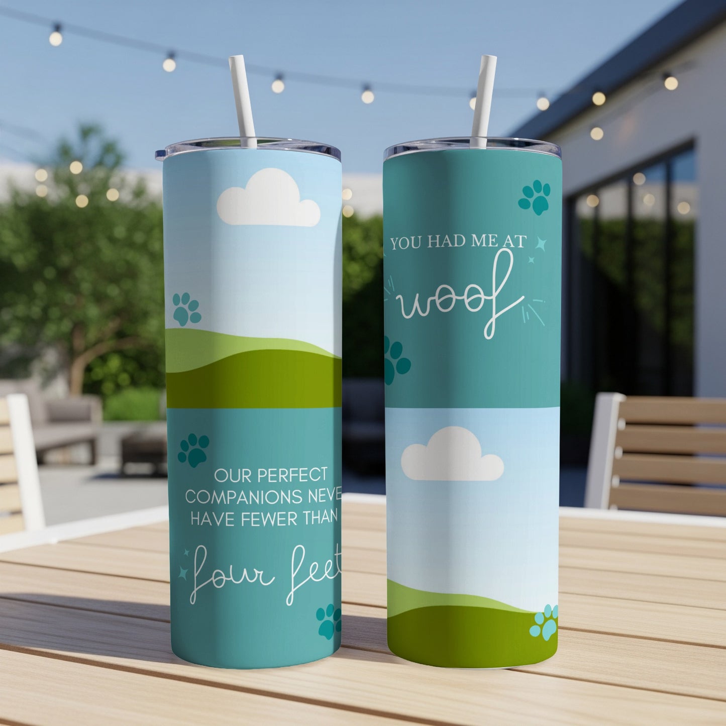 Two tumblers with a sky and rolling green hills design, one reads "You had me at woof".