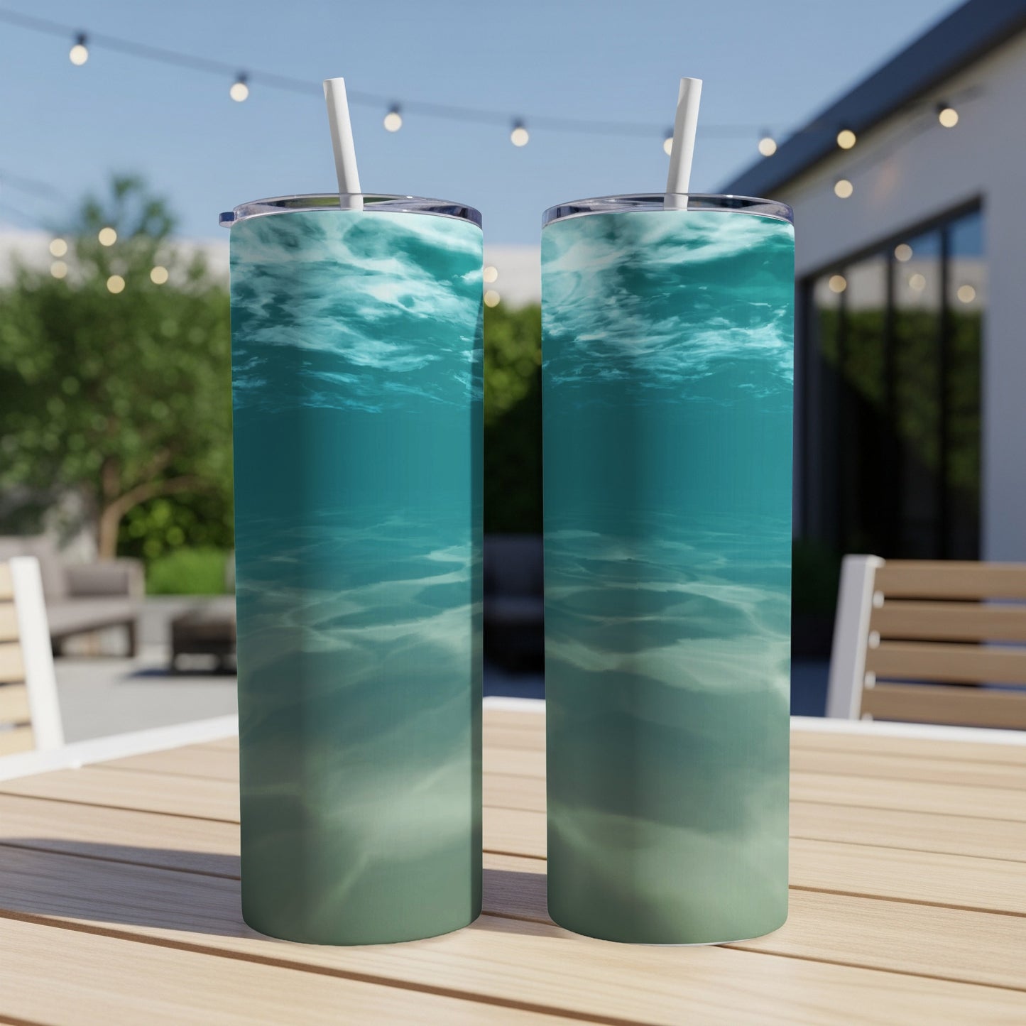 Two tumblers with underwater ocean scene design on a table.